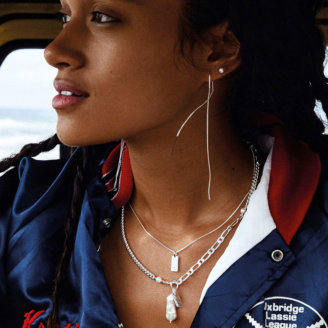 Woman wearing ENCHANTMENT chain earrings, silver-plated, from Pilgrim's collection. Features elongated design with fine long chains for a minimalist, versatile look.