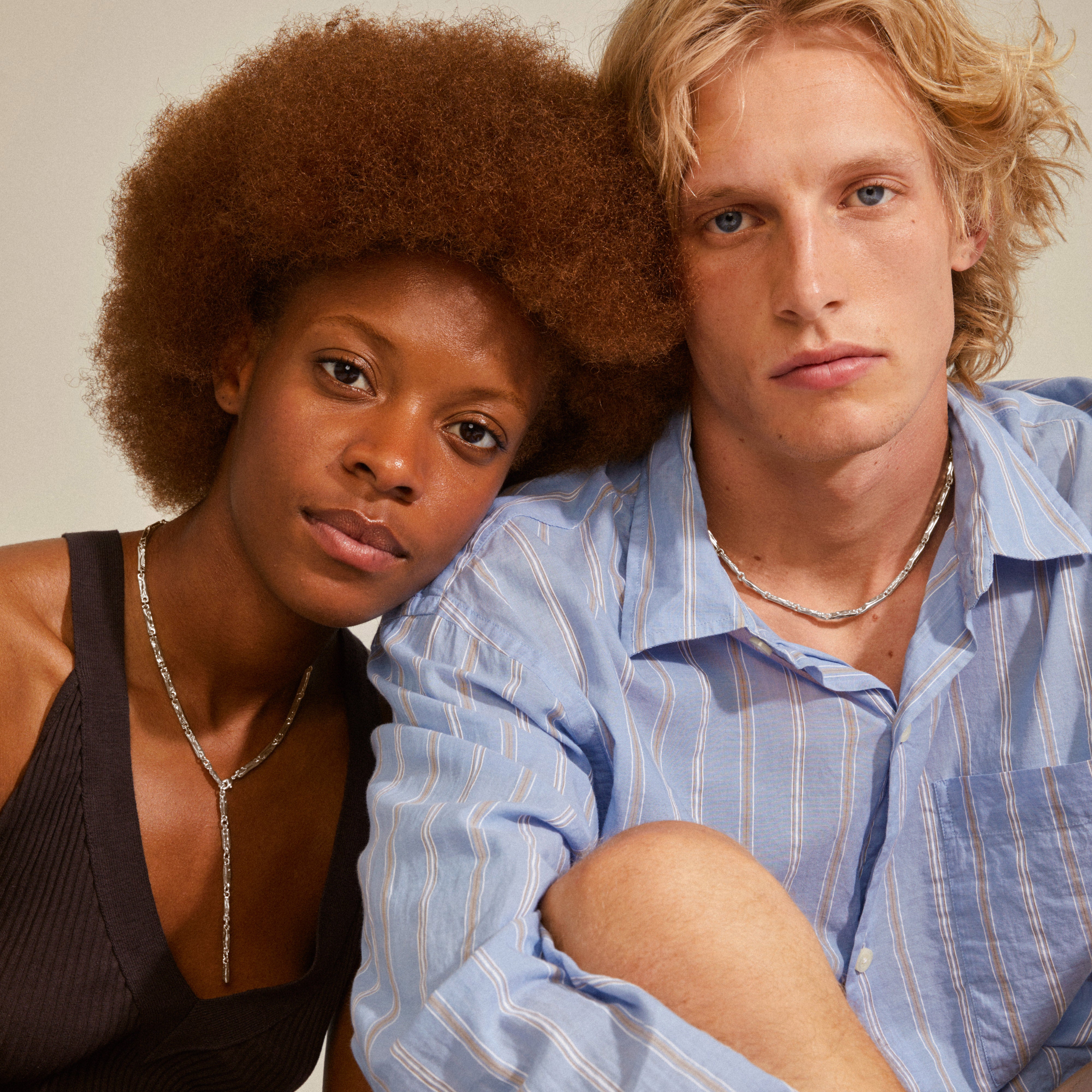 Two young adults wearing Pilgrim's STAR collection silver-plated necklaces, showcasing a modern, unisex design with rectangular links and an edgy finish.