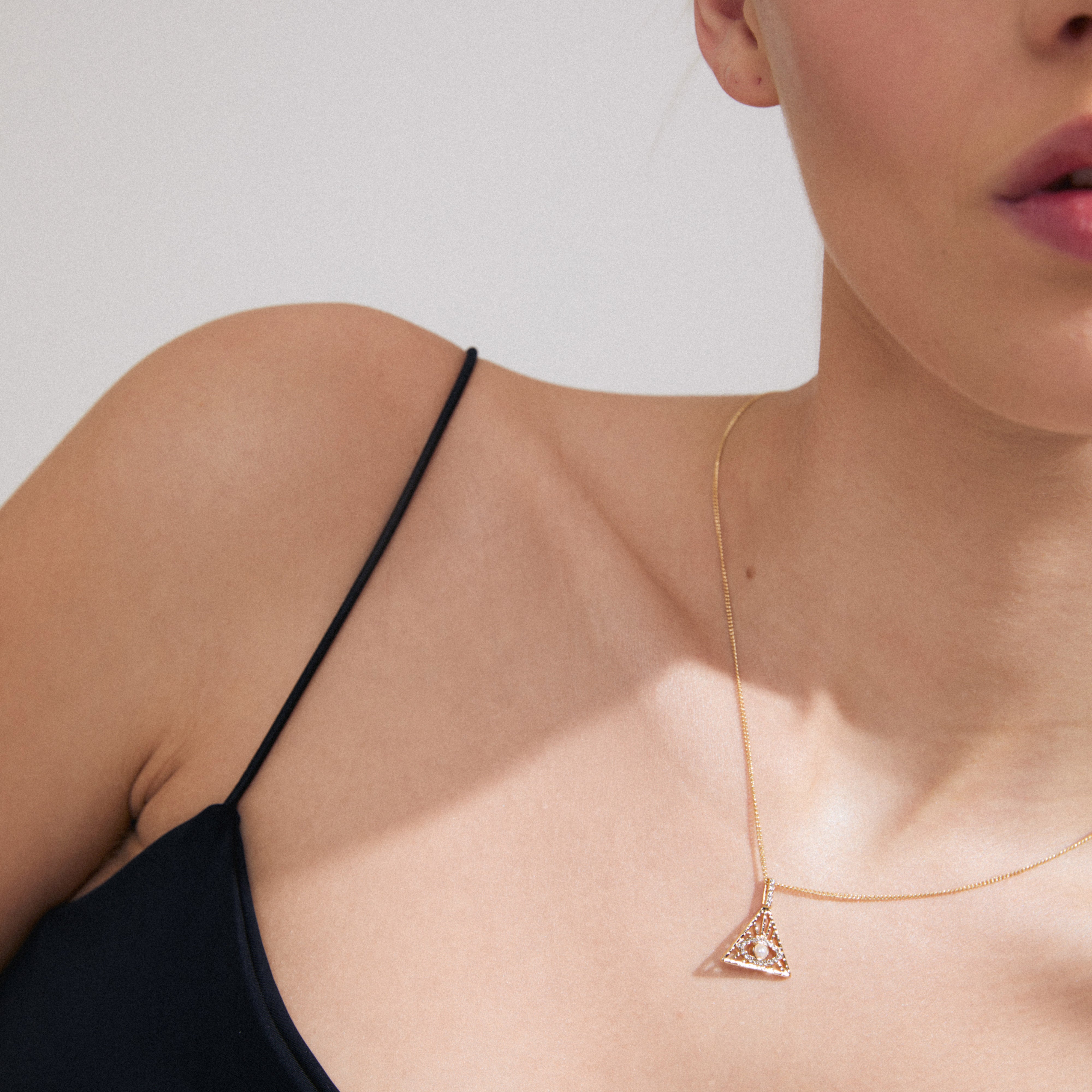FOCUS necklace gold-plated with a triangular pendant featuring Preciosa crystals, worn by a woman, highlighting its luxury bohemian style and adjustable chain.