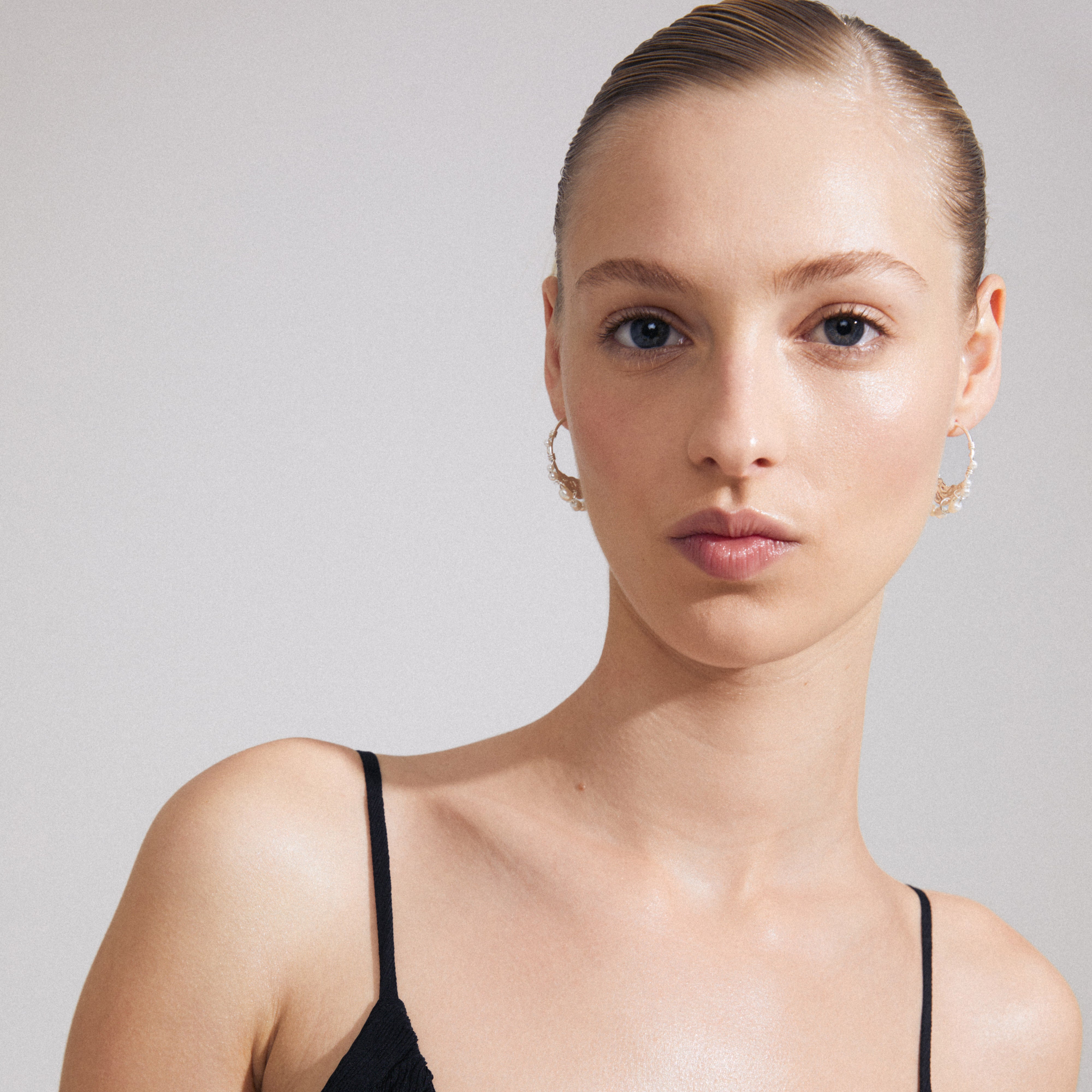 FOCUS hoop earrings, silver-plated with freshwater pearls, worn by a woman. The design exudes a luxurious boho vibe, aligning with Pilgrim's inclusive, trendy ethos.
