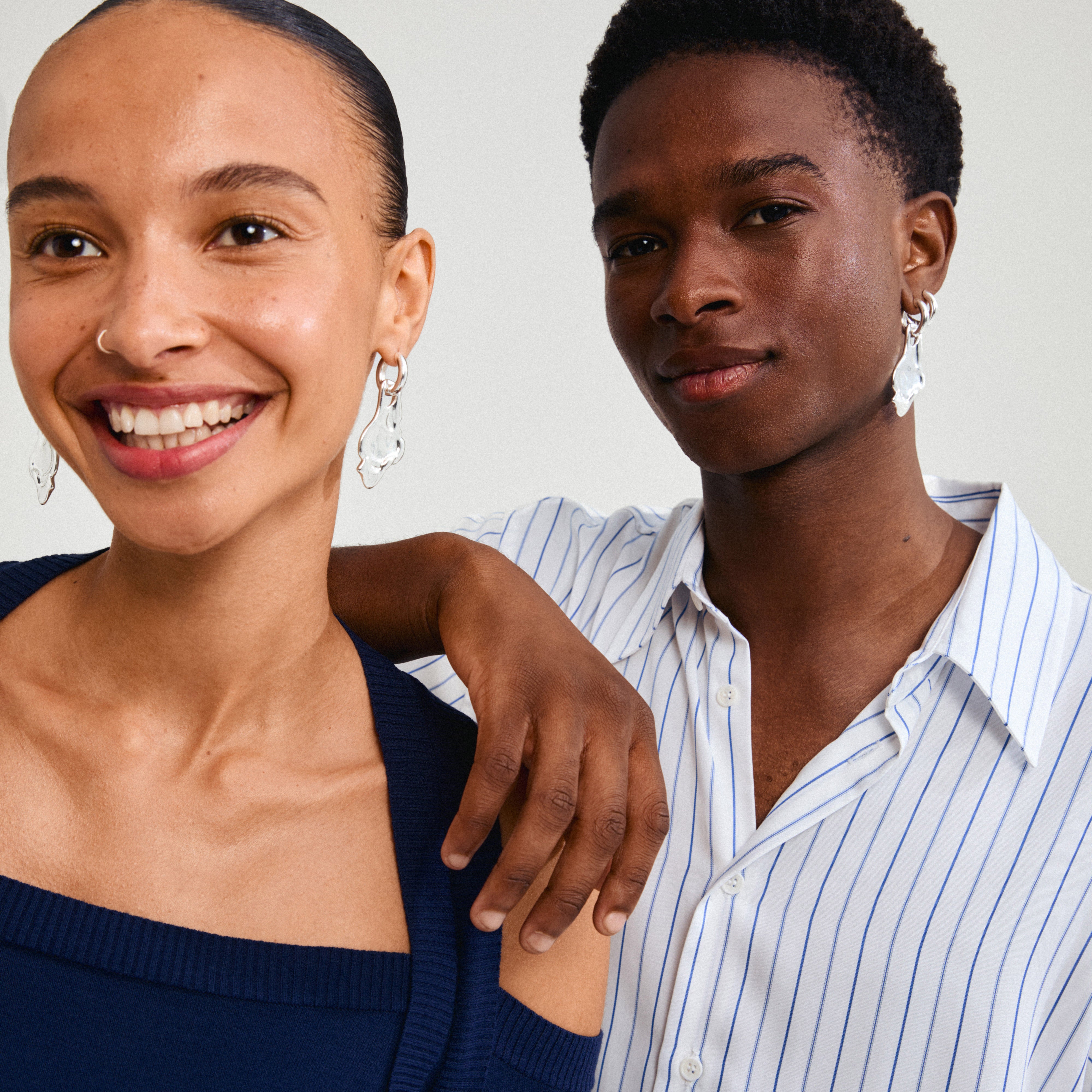 STARLIGHT earrings silver-plated, worn by a smiling woman, feature chunky hoops with organic pendants, capturing a trendy, distinctive statement look.