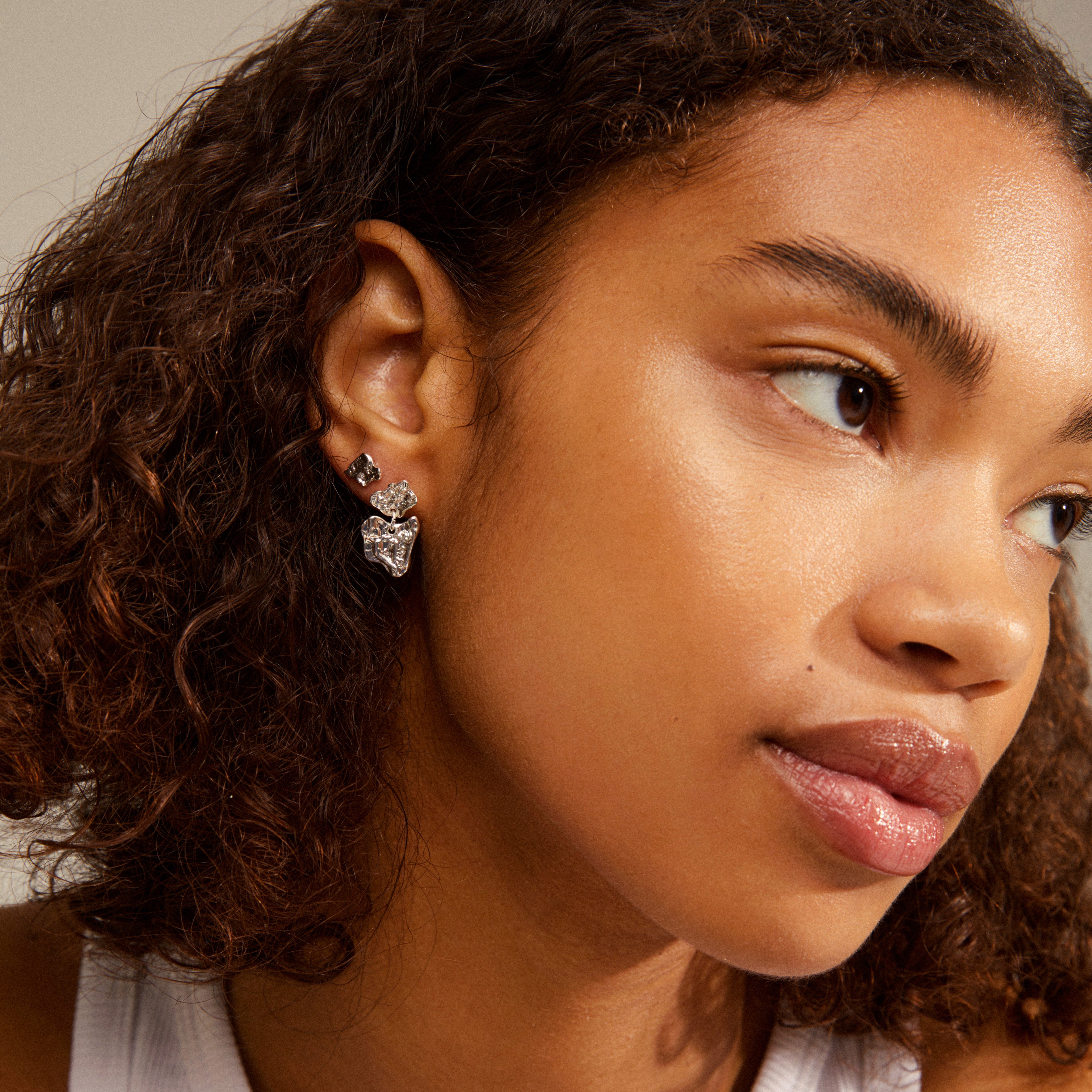 HORIZON earrings silver plated; close-up of a woman's ear adorned with a silver earring from Pilgrim's collection, highlighting a trendy, mix-and-match style.