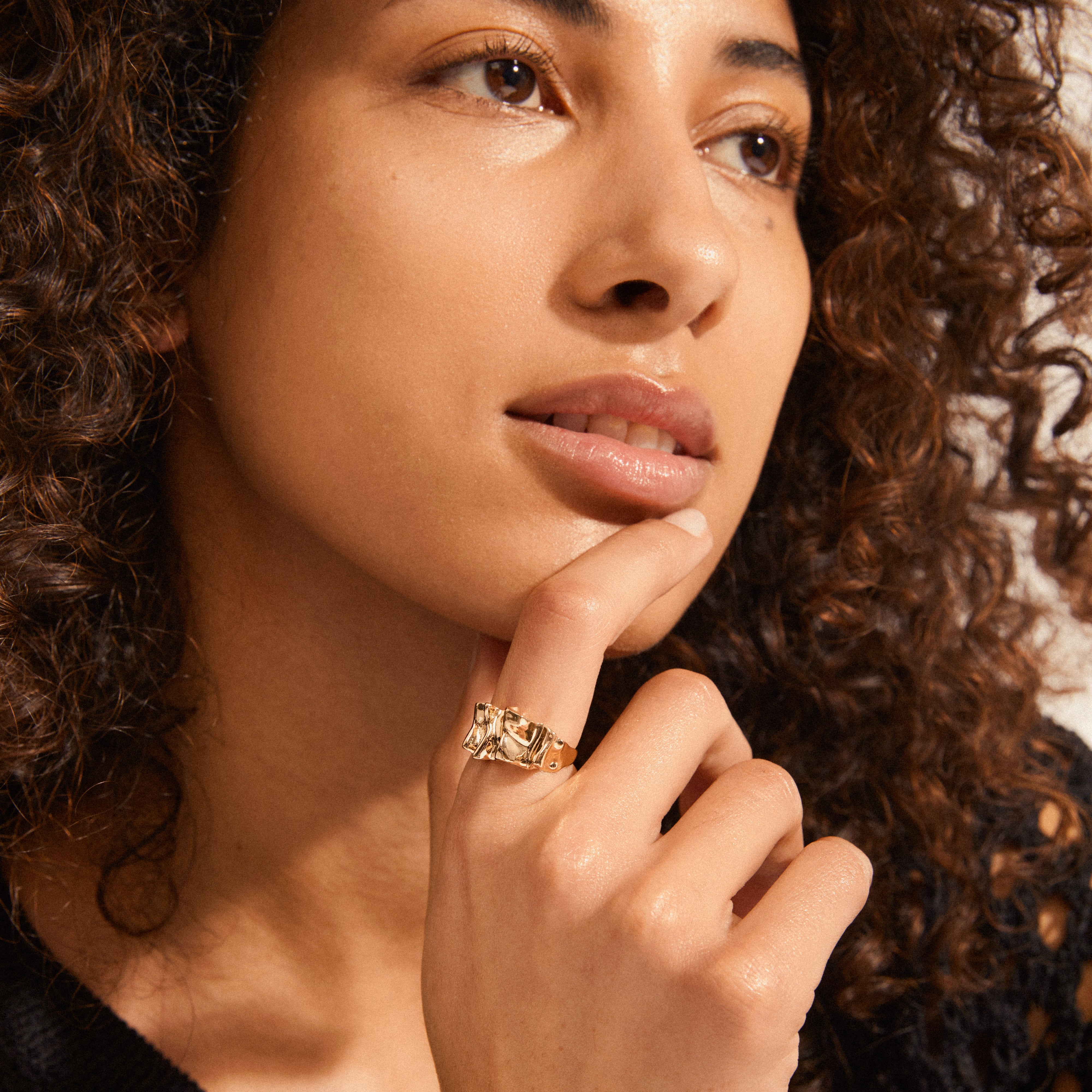 WILLPOWER sculptural ring gold-plated on a woman's finger, showcasing its asymmetrical, nature-inspired design, part of Pilgrim's recycled materials collection.