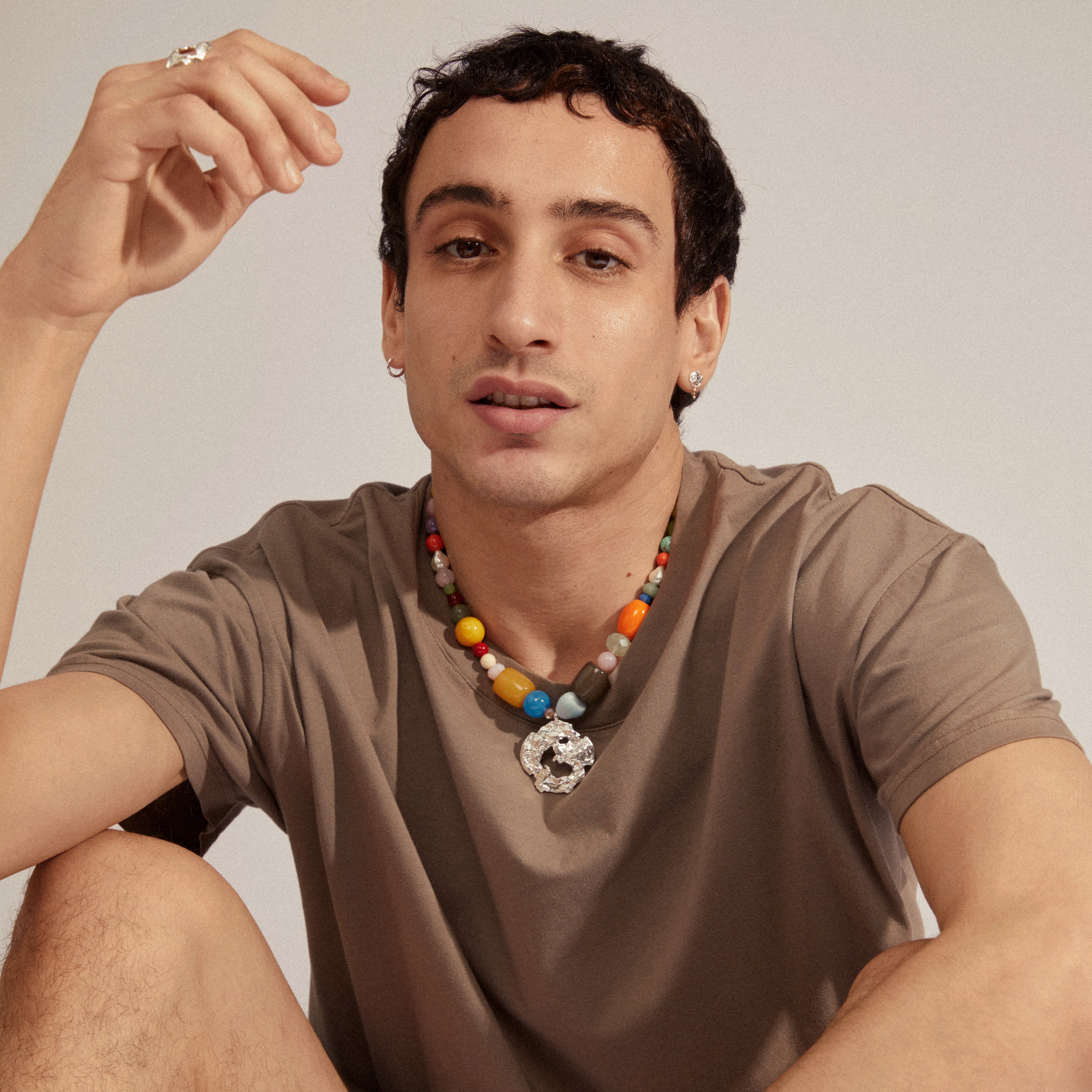 Man wearing SMILE earrings 2-in-1 set, silver-plated with colorful pearl pendants, showcasing Pilgrim's trendy, Scandinavian-inspired jewelry.
