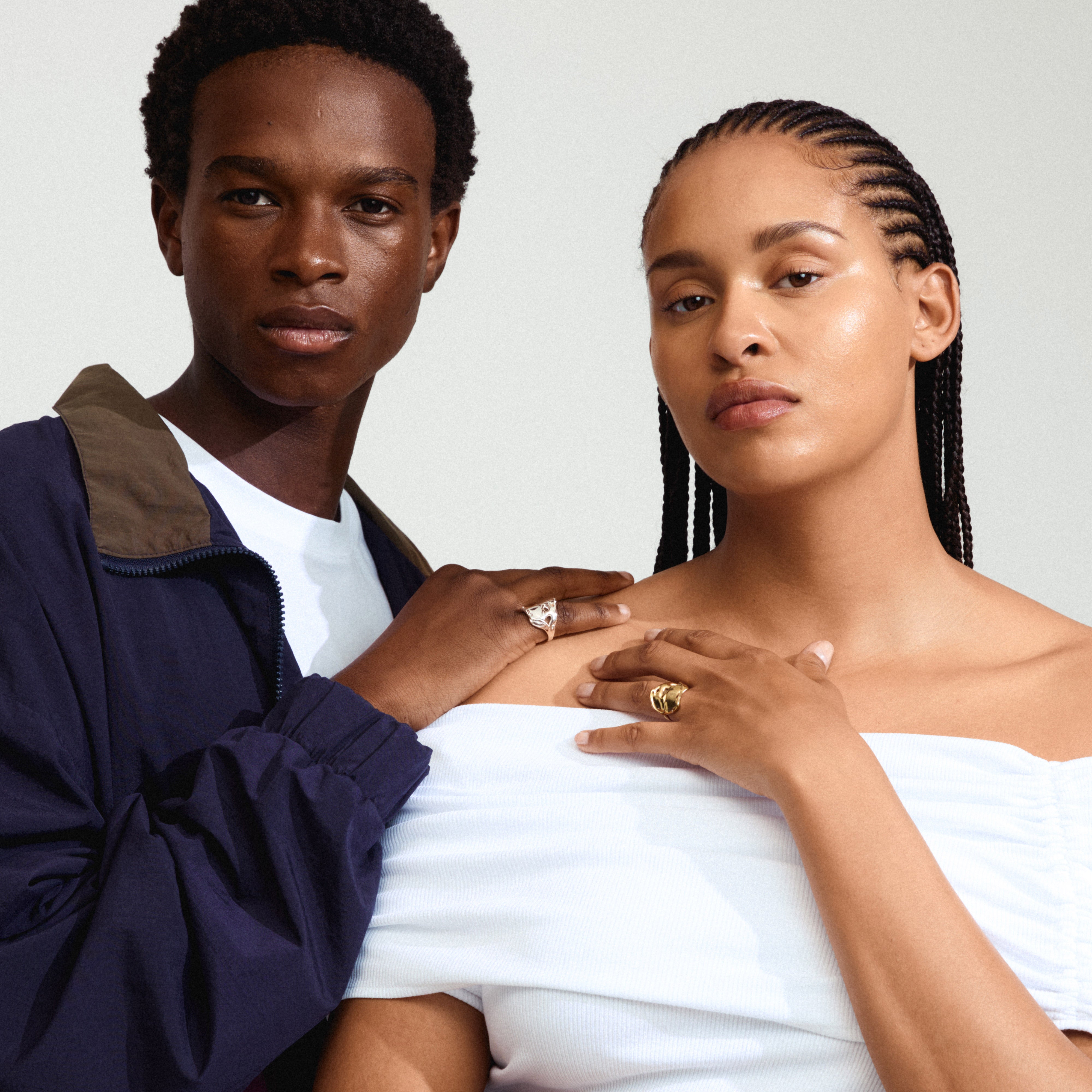 DAWN silver-plated ring with an organic, handcrafted look, worn by a man and woman. The ring features a shiny surface, enhancing their stylish appearance.