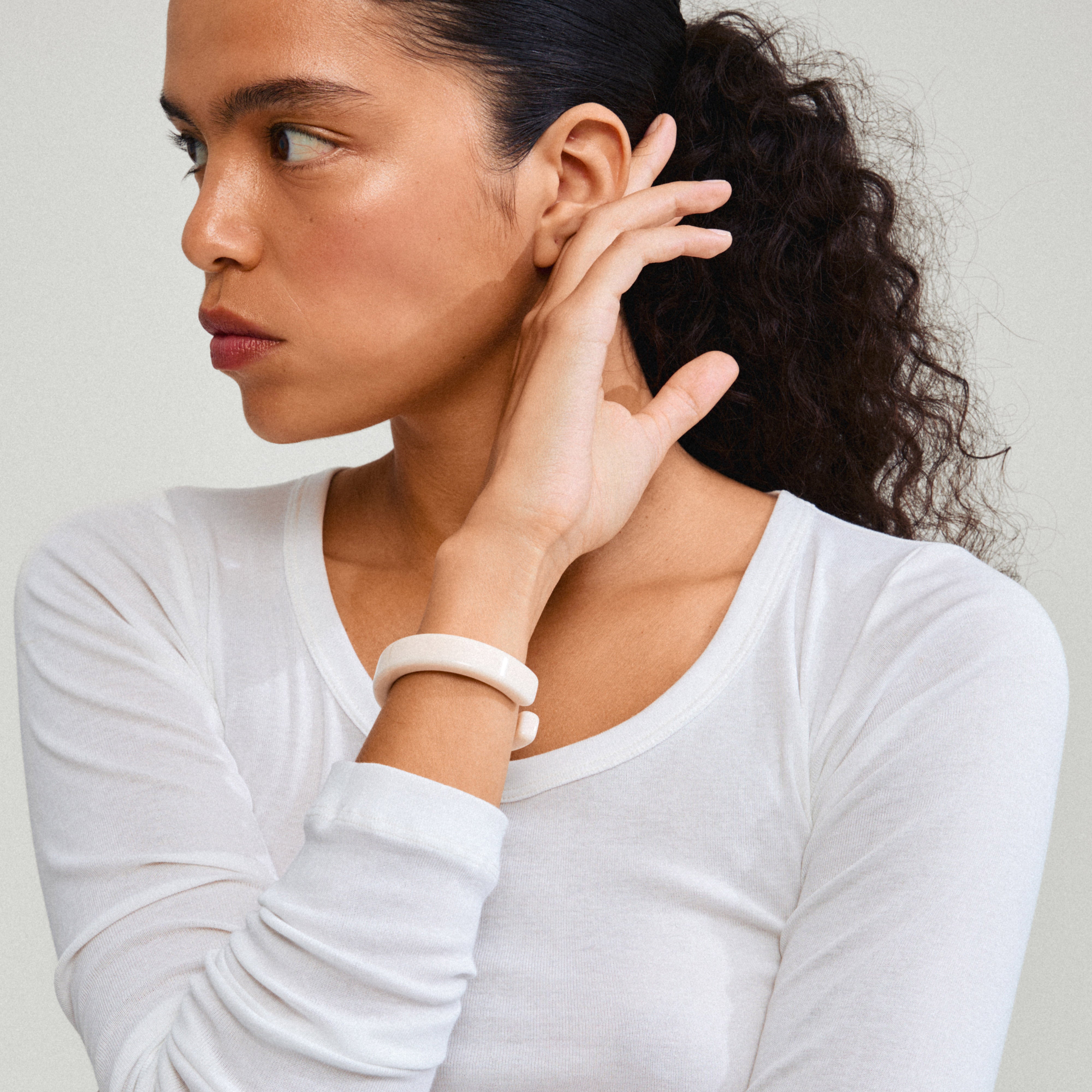 ECLIPSE bangle white on a woman's wrist, showcasing its simple, chic design in recycled acrylic, part of Pilgrim's sustainable, trendy jewelry collection.