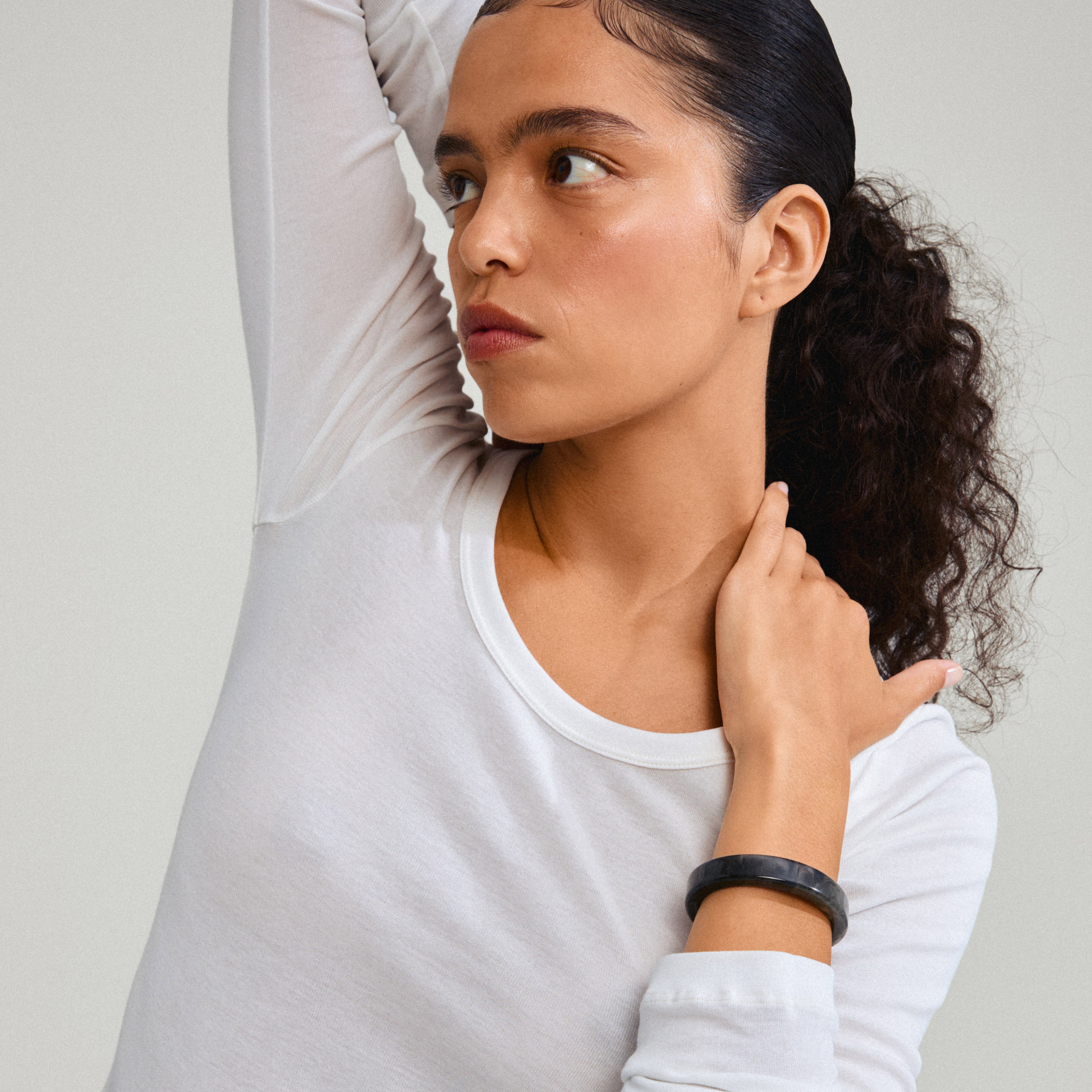 Close-up of a woman wearing the ECLIPSE bangle in marbled grey, highlighting its trendy, earthy design and recycled material.