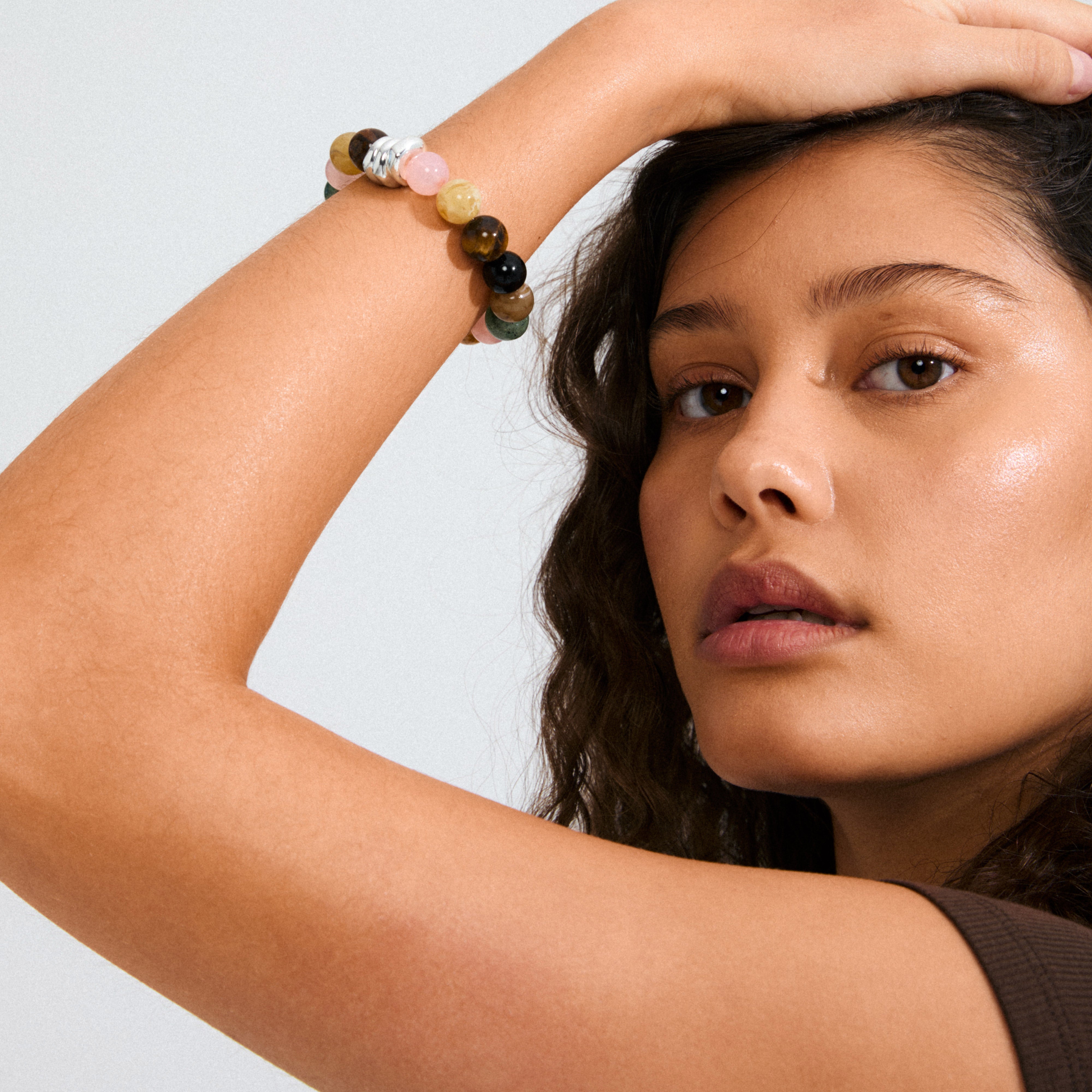 Young woman wearing the UNFOLD bracelet with multicolored stone beads and silver accents, showcasing Pilgrim's blend of timeless design and contemporary style.