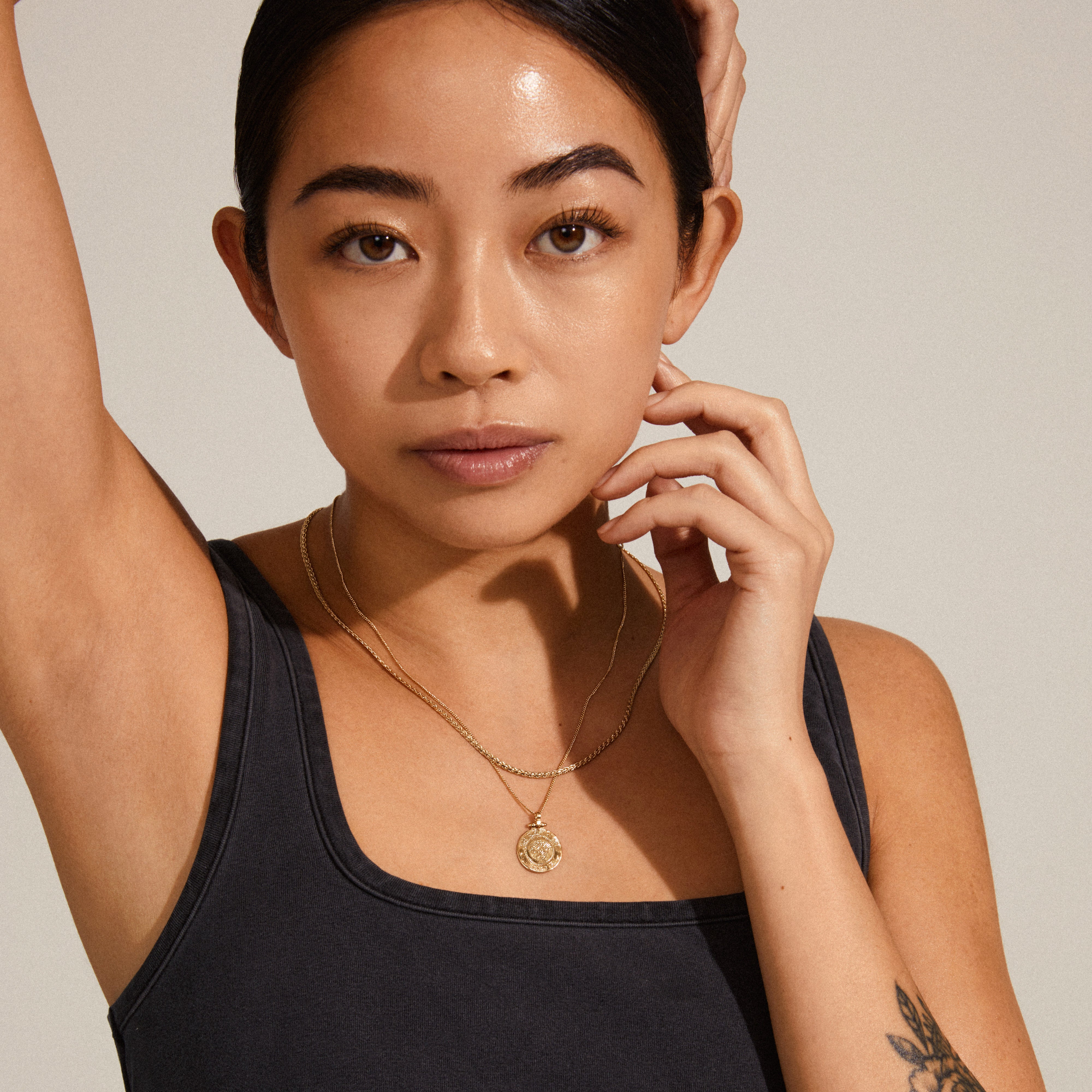 NOMAD 2-in-1 coin necklace gold-plated worn by a woman, showcasing its layered design with two separate chains, perfect for a chic, trendy look.