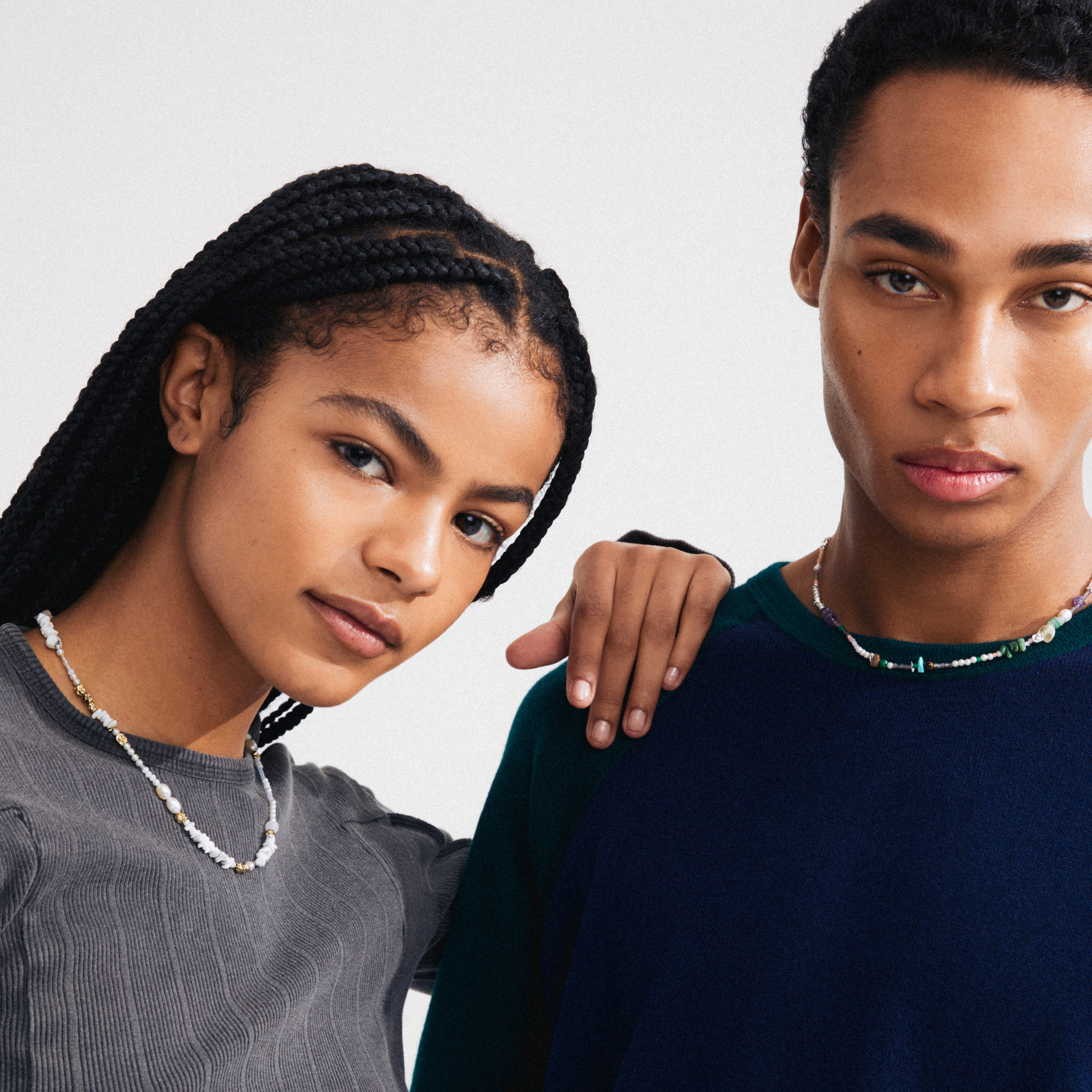 Young woman and man wearing Pilgrim's FORCE necklace, showcasing multicolored beads and silver-plated details, each displaying calm expressions against a neutral backdrop.