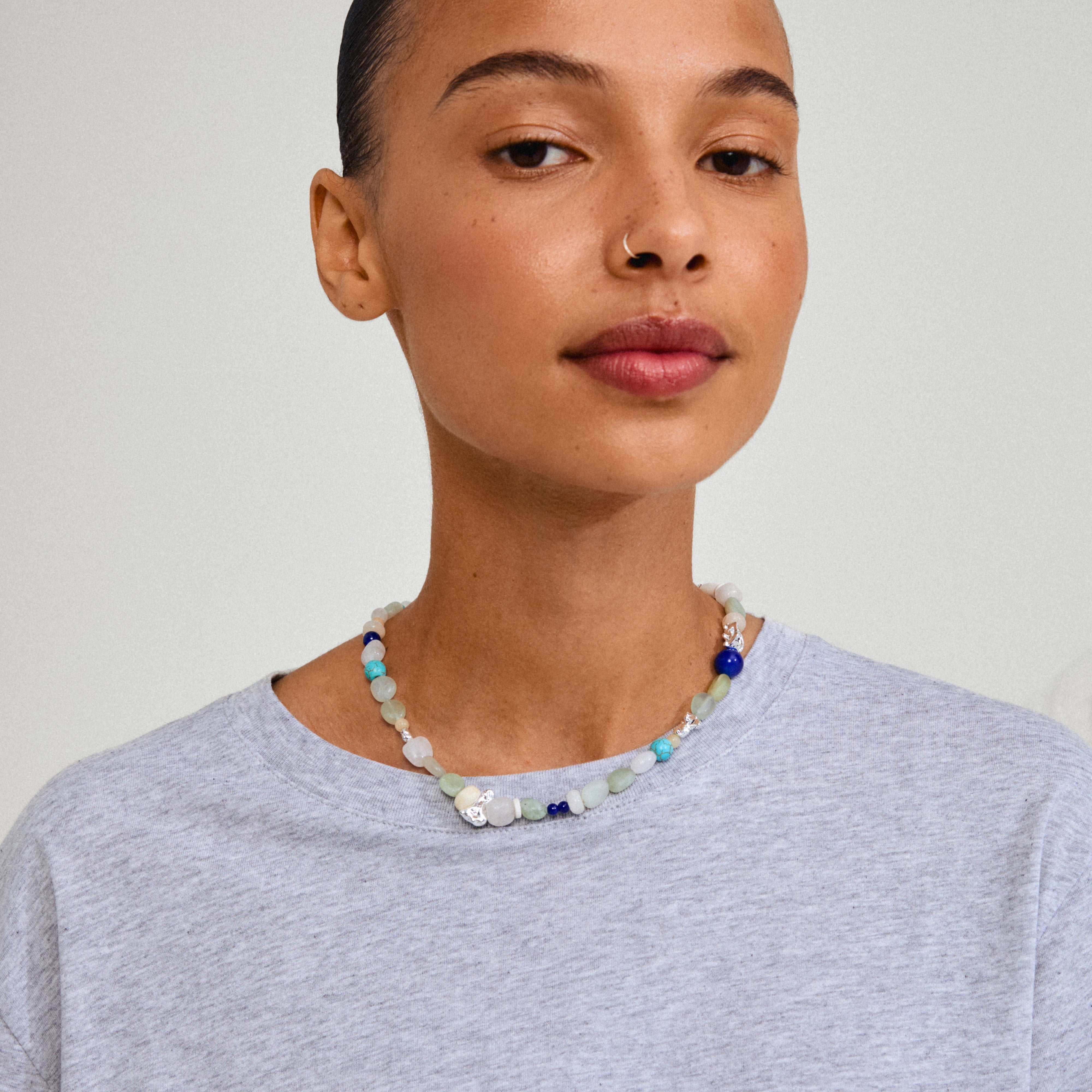 Close-up of a woman wearing the DREAM necklace, featuring semi-precious stones and silver-plated details, embodying Pilgrim's stylish, handmade jewellery design.