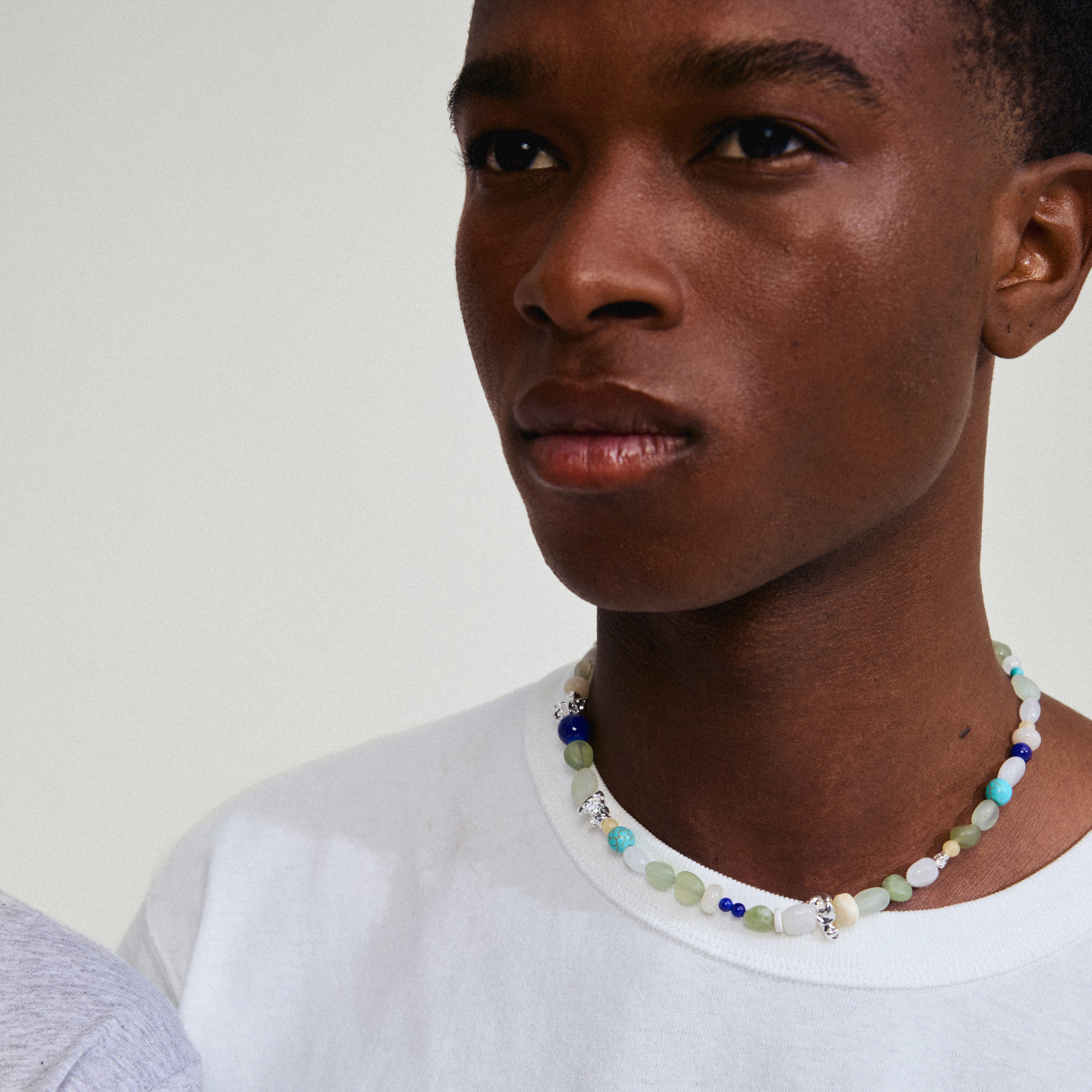 DREAM necklace blue/silver-plated featuring semi-precious stones and glass beads worn by a man in a white shirt, showcasing Pilgrim's trendy Danish design.