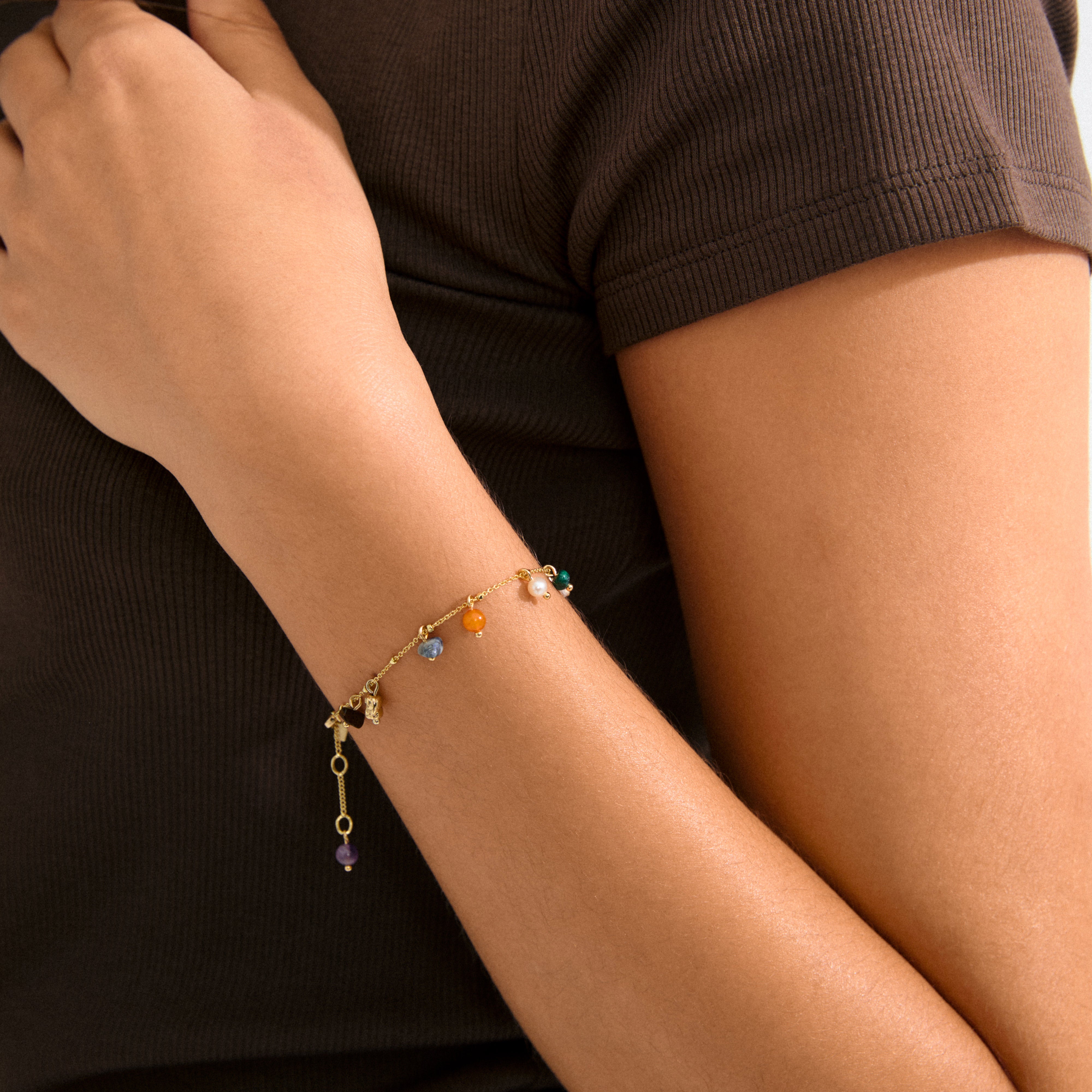 Close-up of Pilgrim's BETWEEN bracelet, gold-plated with semi-precious stones on a wrist, showcasing its luxe boho vibe and stylish, grounded appeal.