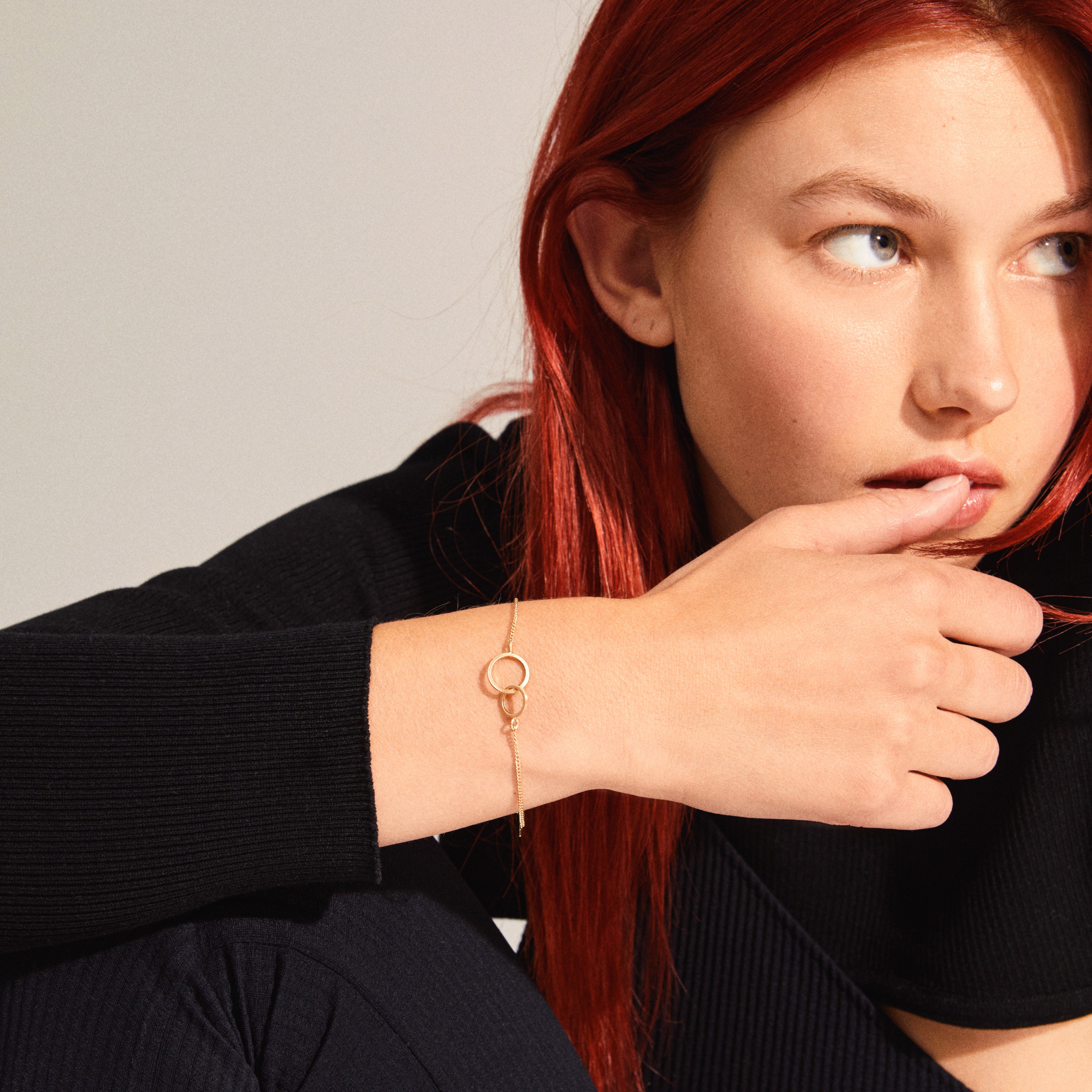 Gold-plated HARPER bracelet featuring two intertwined rings, elegantly showcased on a woman's wrist, capturing the essence of timeless Scandinavian craftsmanship by Pilgrim.
