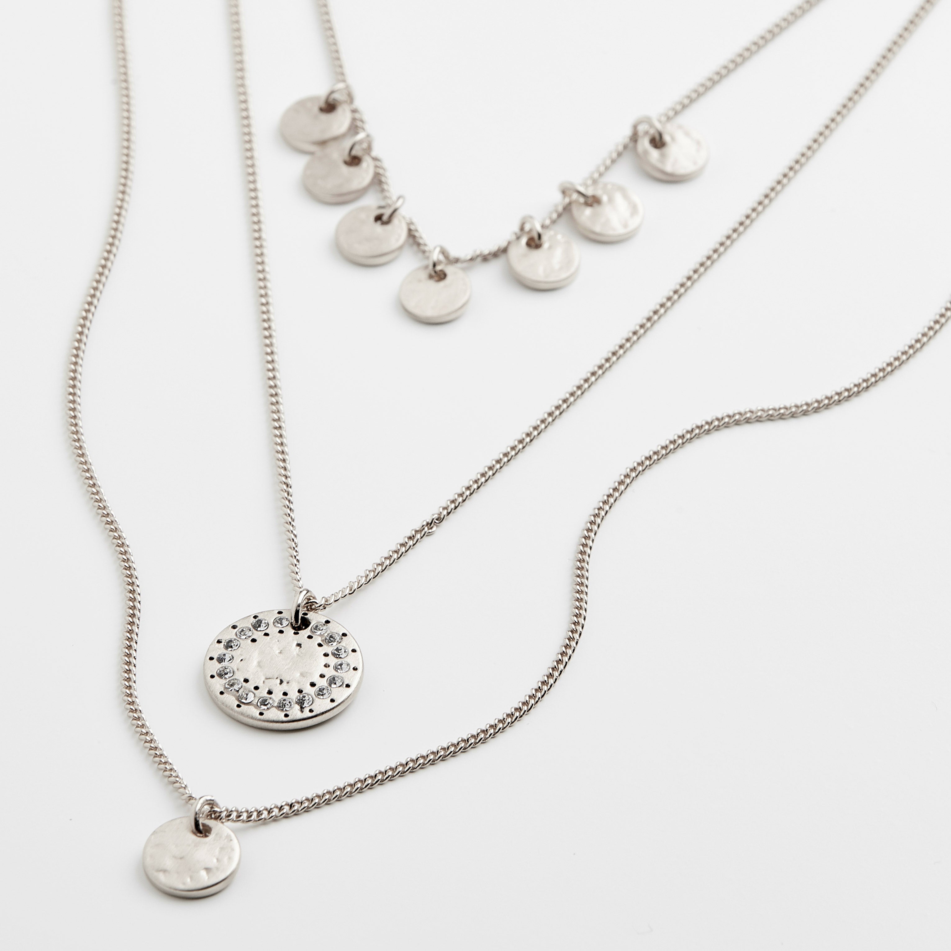 Silver-plated ARDEN 3-in-1 crystal necklace featuring rustic amulets and sparkling crystals, offering a unique, feminine design with intricate details.