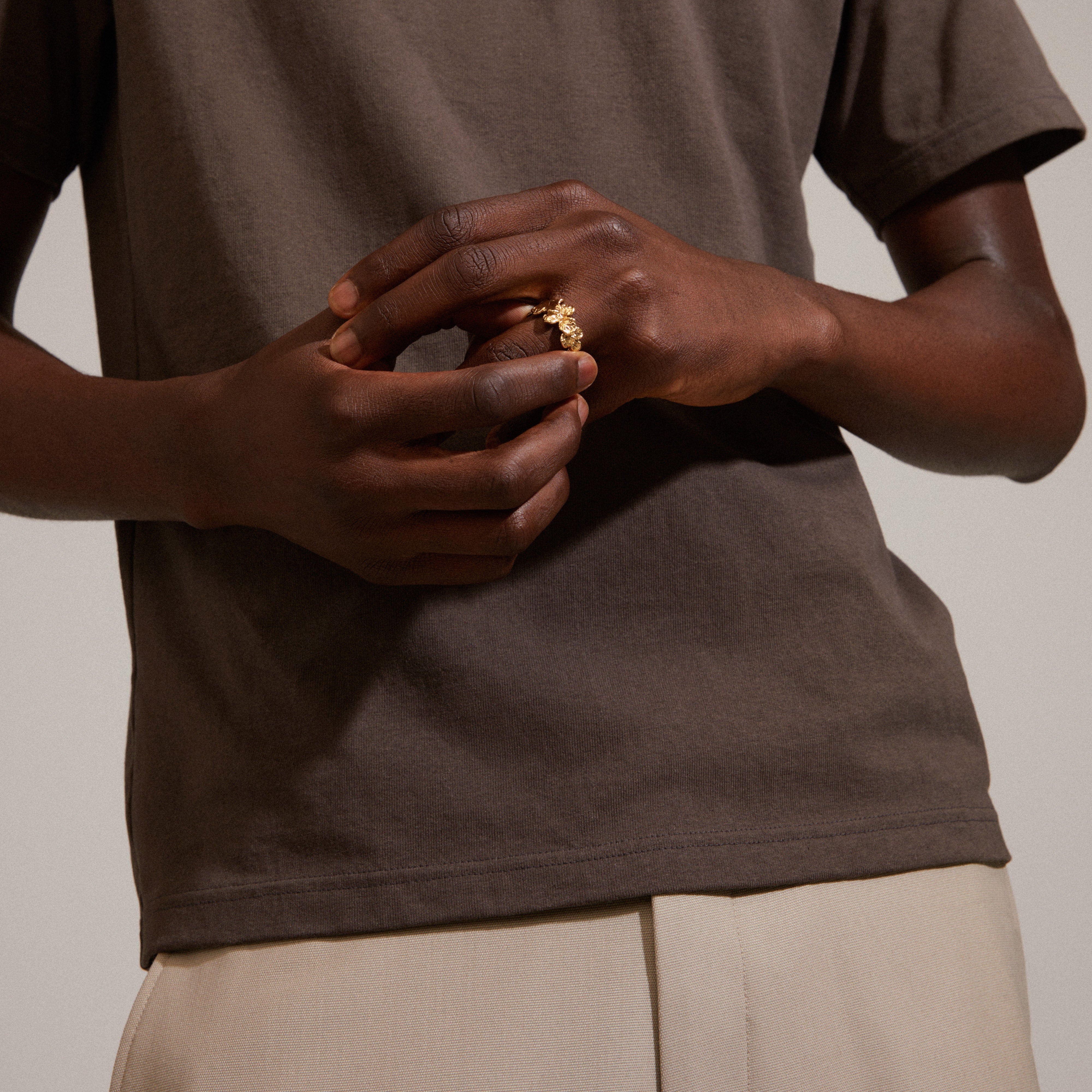 ECHO ring gold-plated on a person's finger, showcasing a handcrafted floral design, embodying Pilgrim's nature-inspired style with recycled materials.