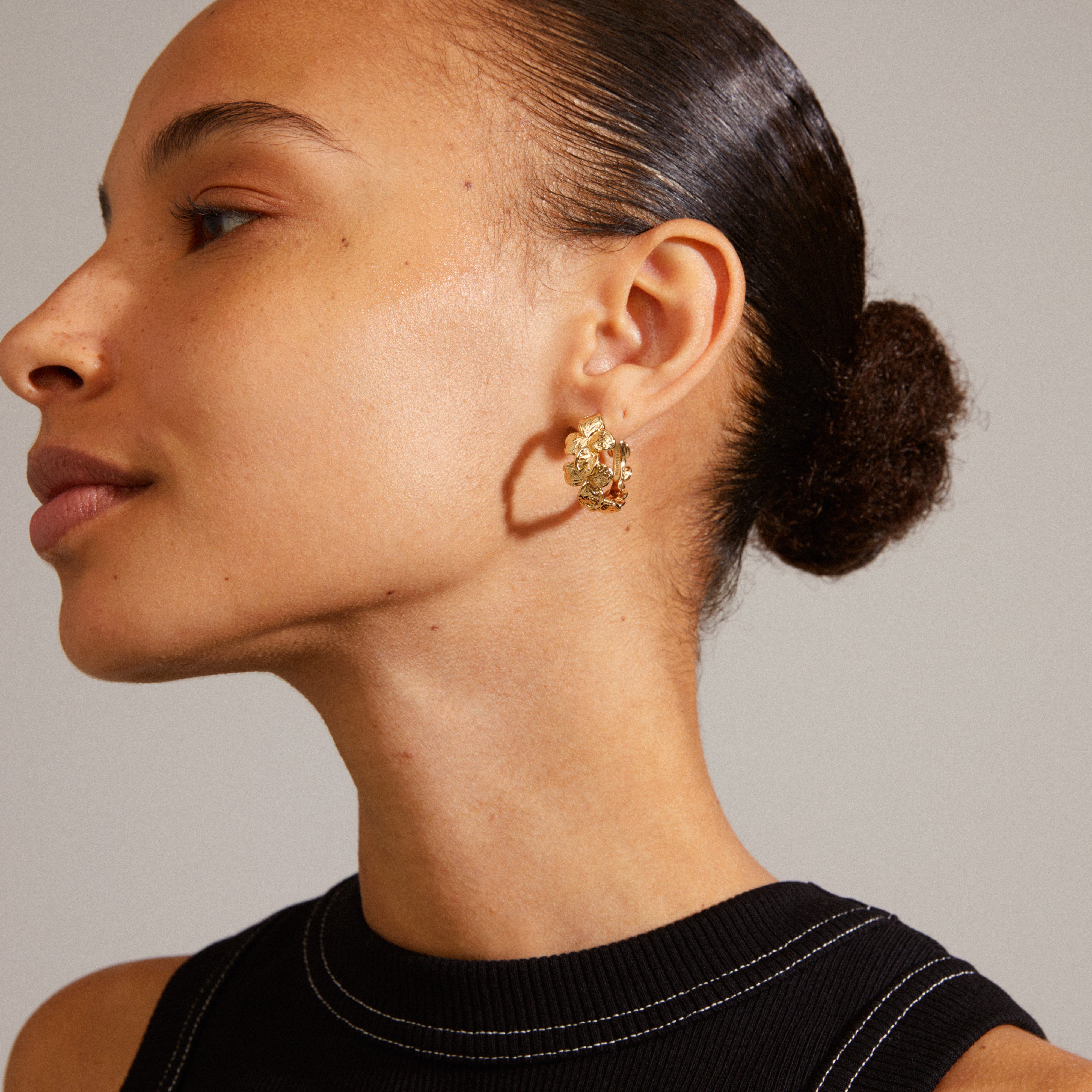 Gold-plated ECHO hoop earrings with a romantic flower design, worn close to a woman's ear, showcasing Pilgrim's unique, classic style.