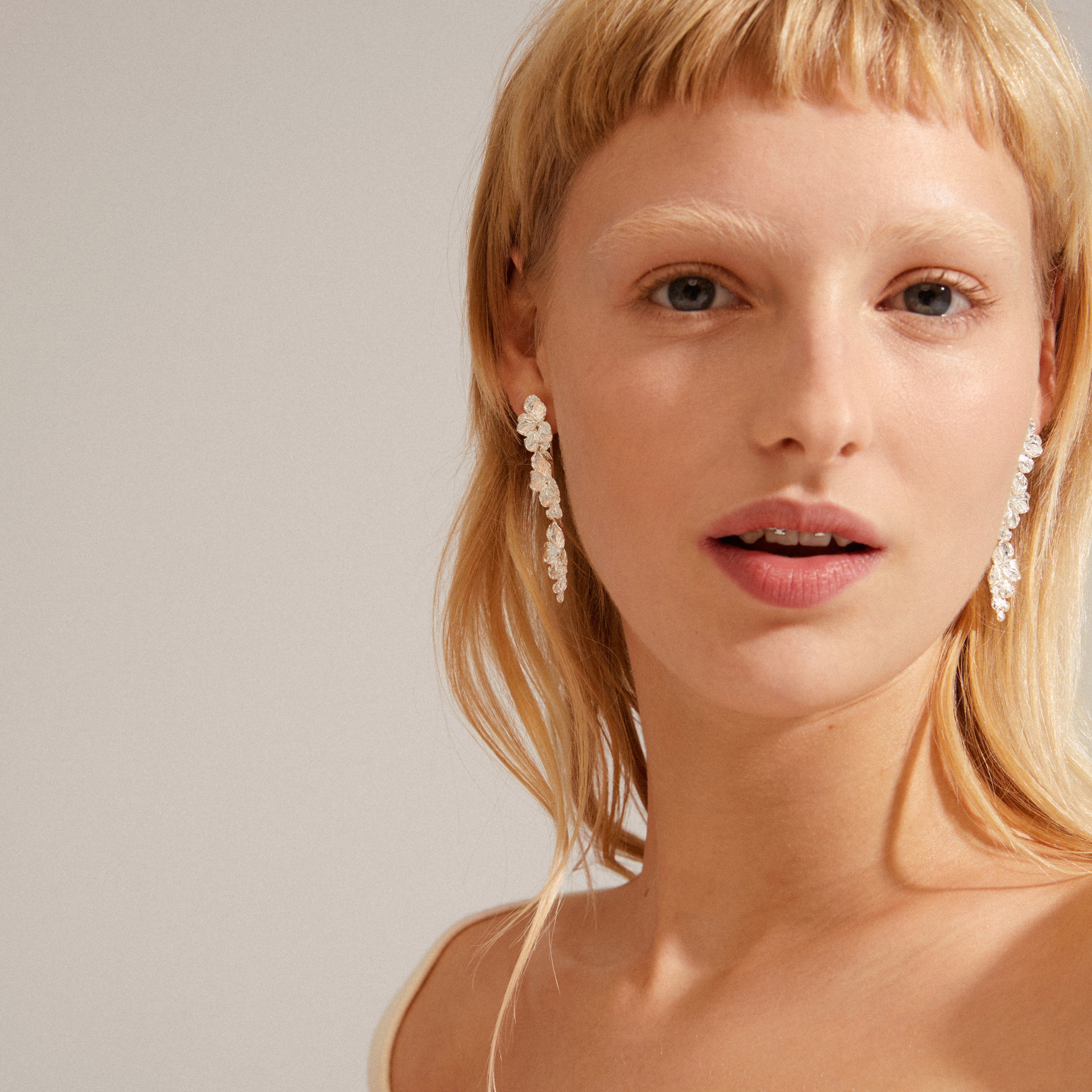 ECHO earrings silver-plated with flowery, movable links worn by a woman, showcasing Pilgrim's nature-inspired design and craftsmanship.