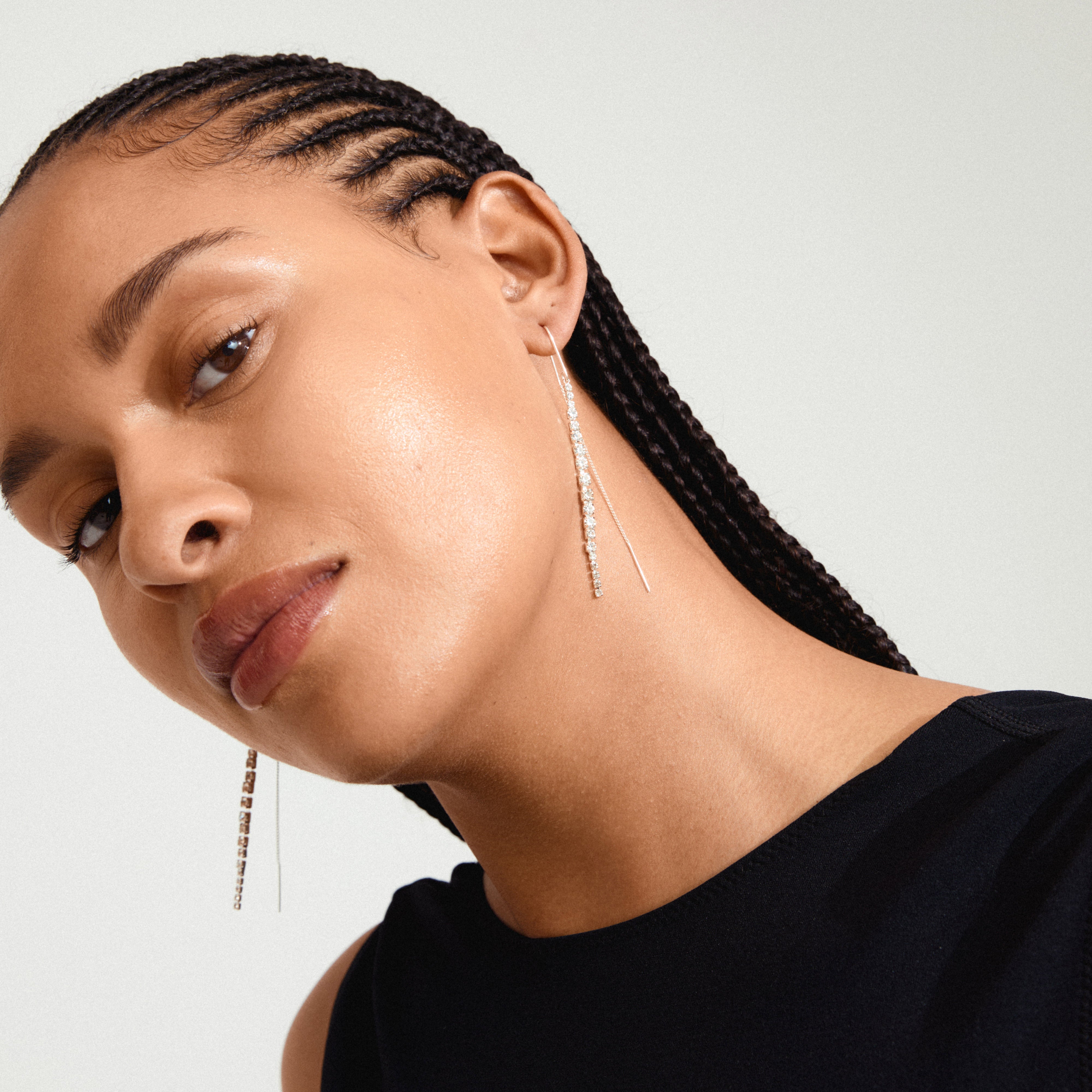 Silver-plated SKY chain earrings with dazzling Preciosa crystals, worn by a woman with long braids, showcasing elegance and sophistication from Pilgrim's collection.