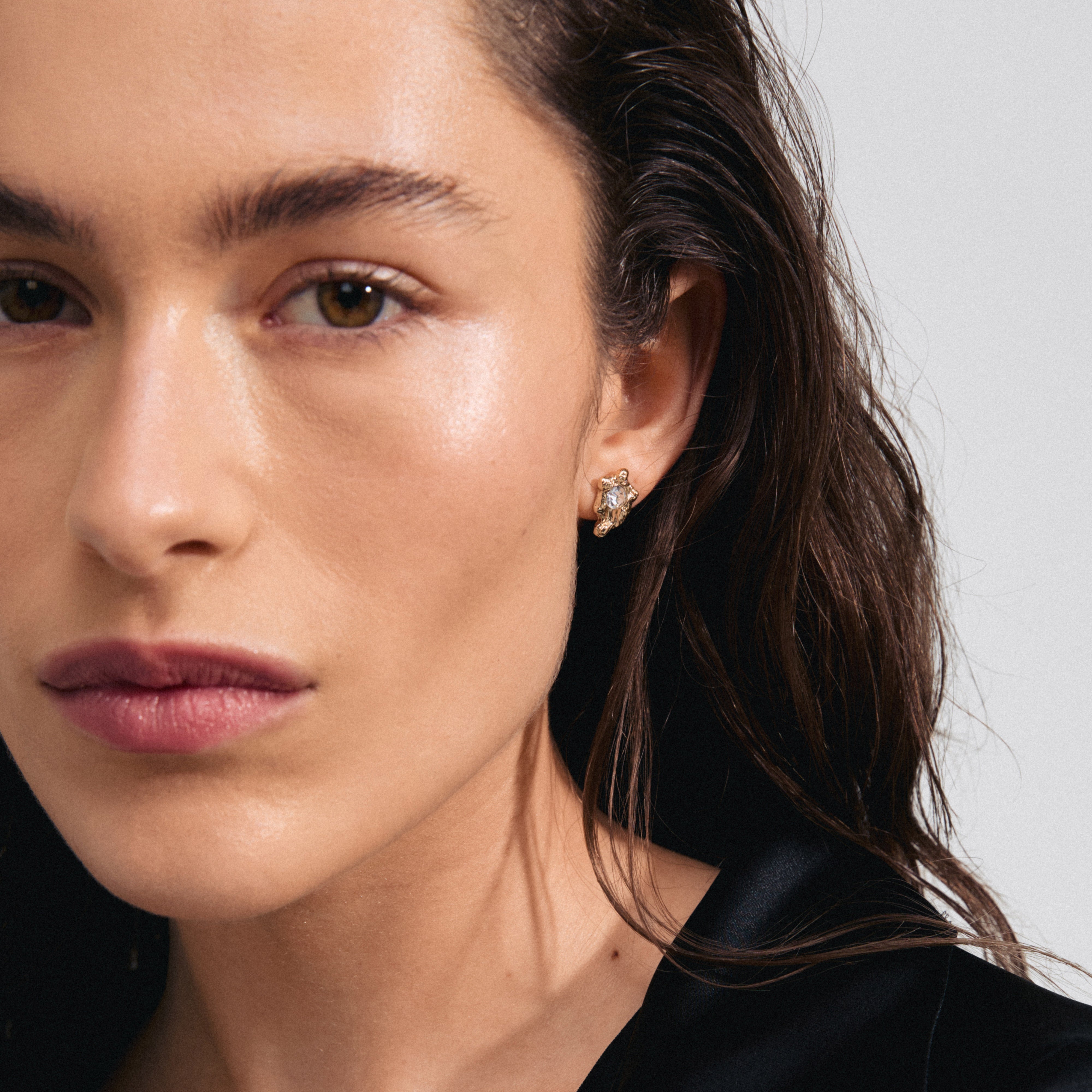 Close-up of a woman wearing AIAS crystal earrings gold-plated, featuring a nature-inspired design with sparkling Preciosa crystals, perfect for adding elegance to everyday style.