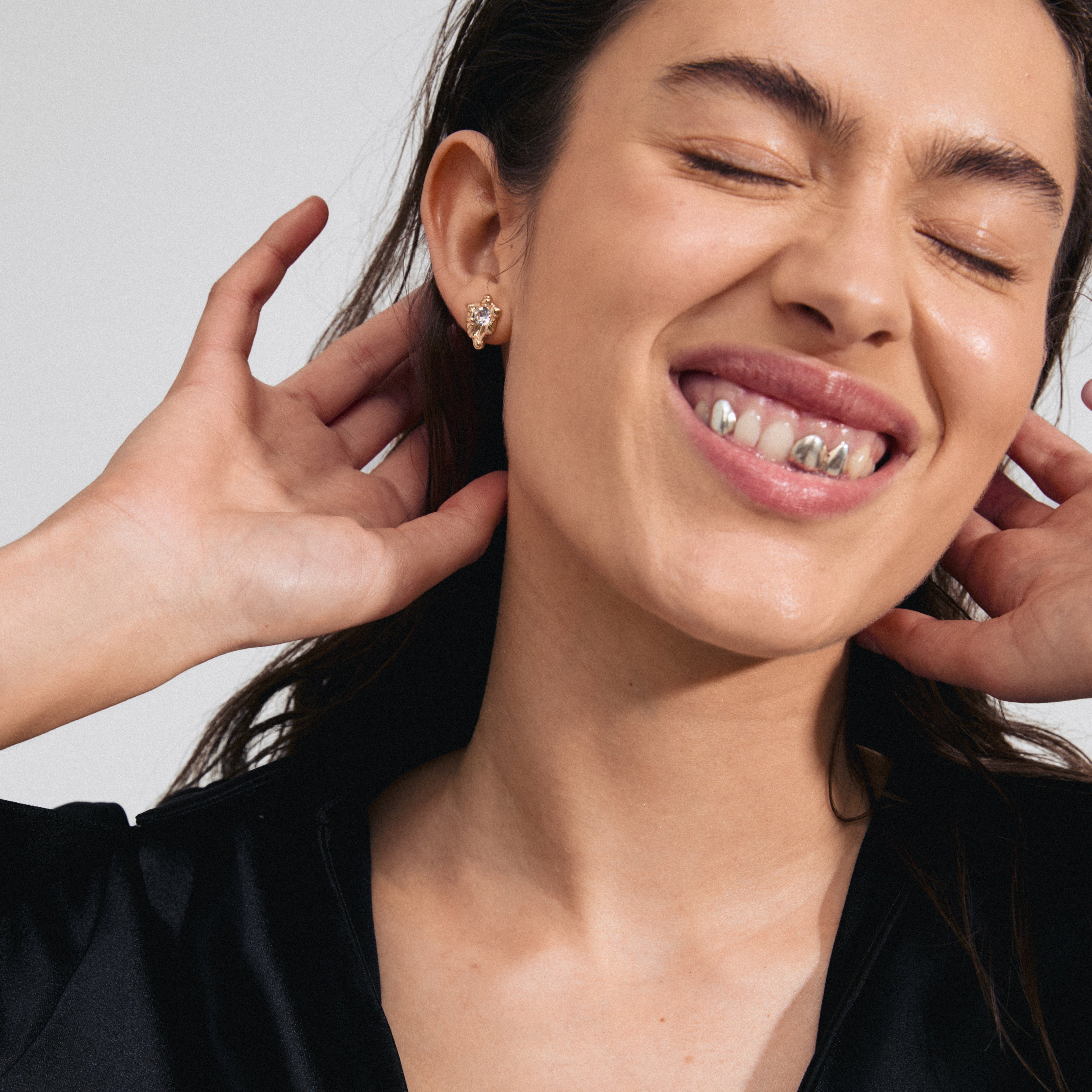 AIAS crystal earrings gold-plated: woman wears organic-design gold stud earrings with sparkling Preciosa crystals, embodying nature's elegance and sustainable craftsmanship.