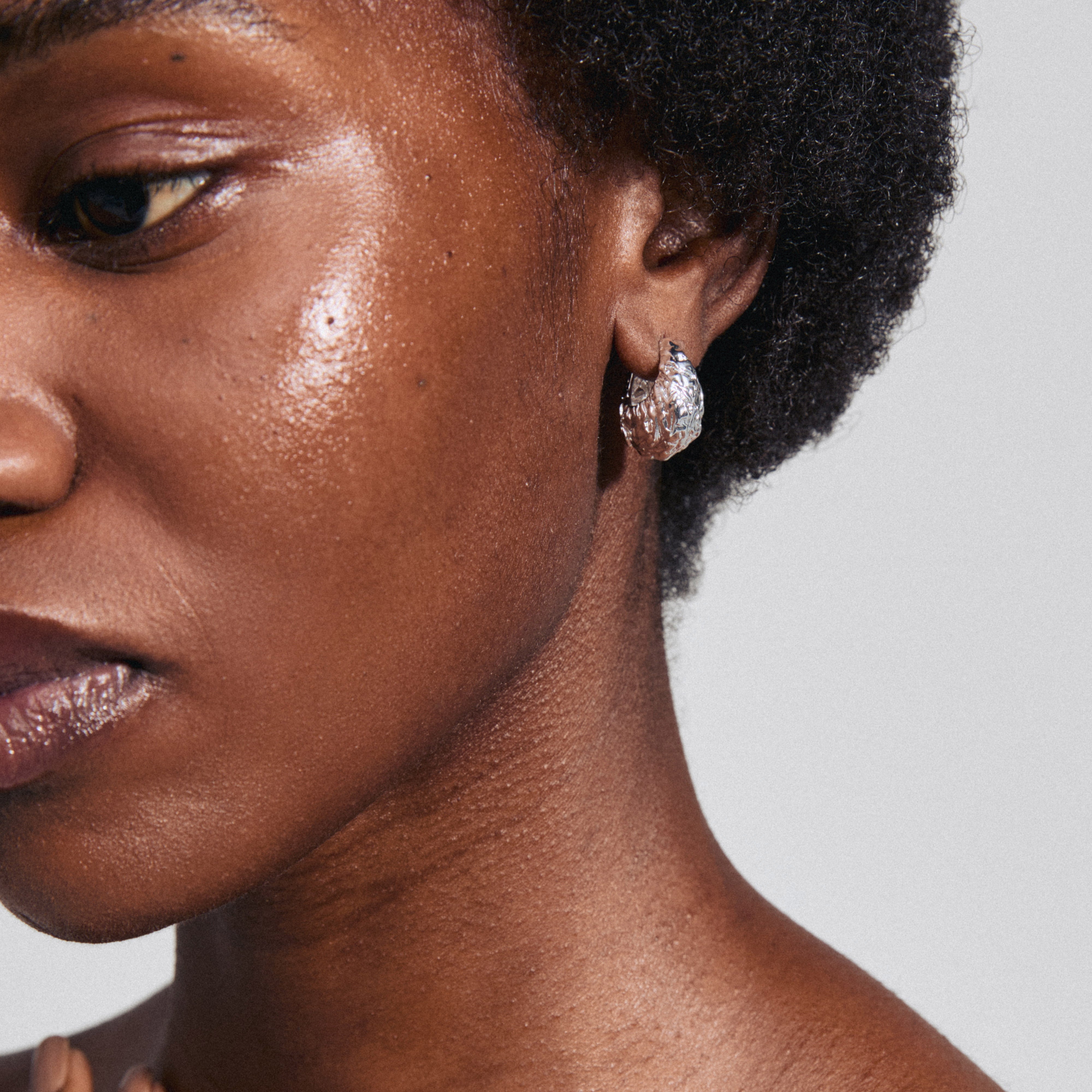 LINCOLN silver-plated earrings showcase chunky, rustic hoops with a shiny finish, featuring an easy click clasp for everyday wear.