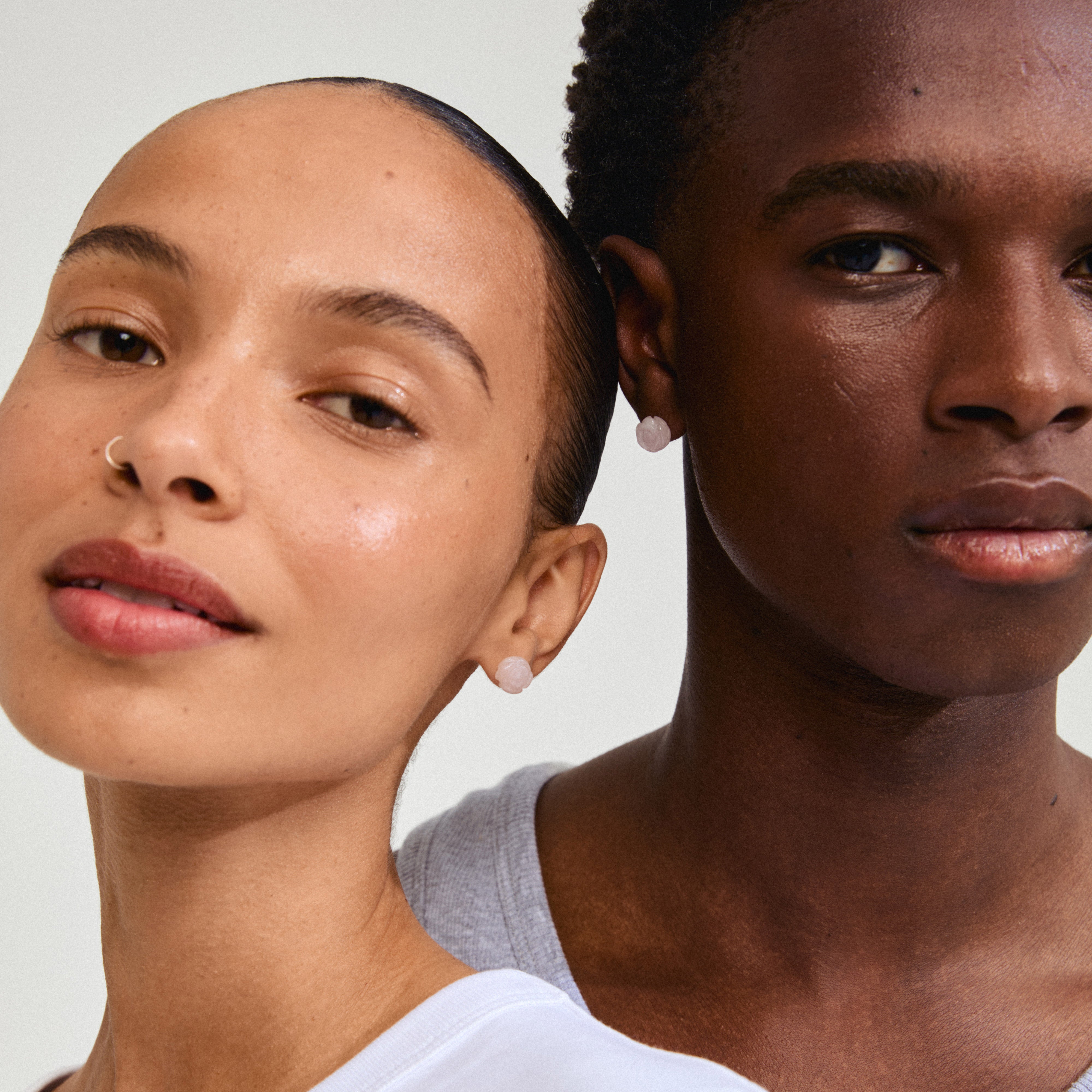 ADEM rosequartz earrings intricately carved into roses, worn by a woman, showcasing their natural elegance and romantic allure in a close-up portrait.