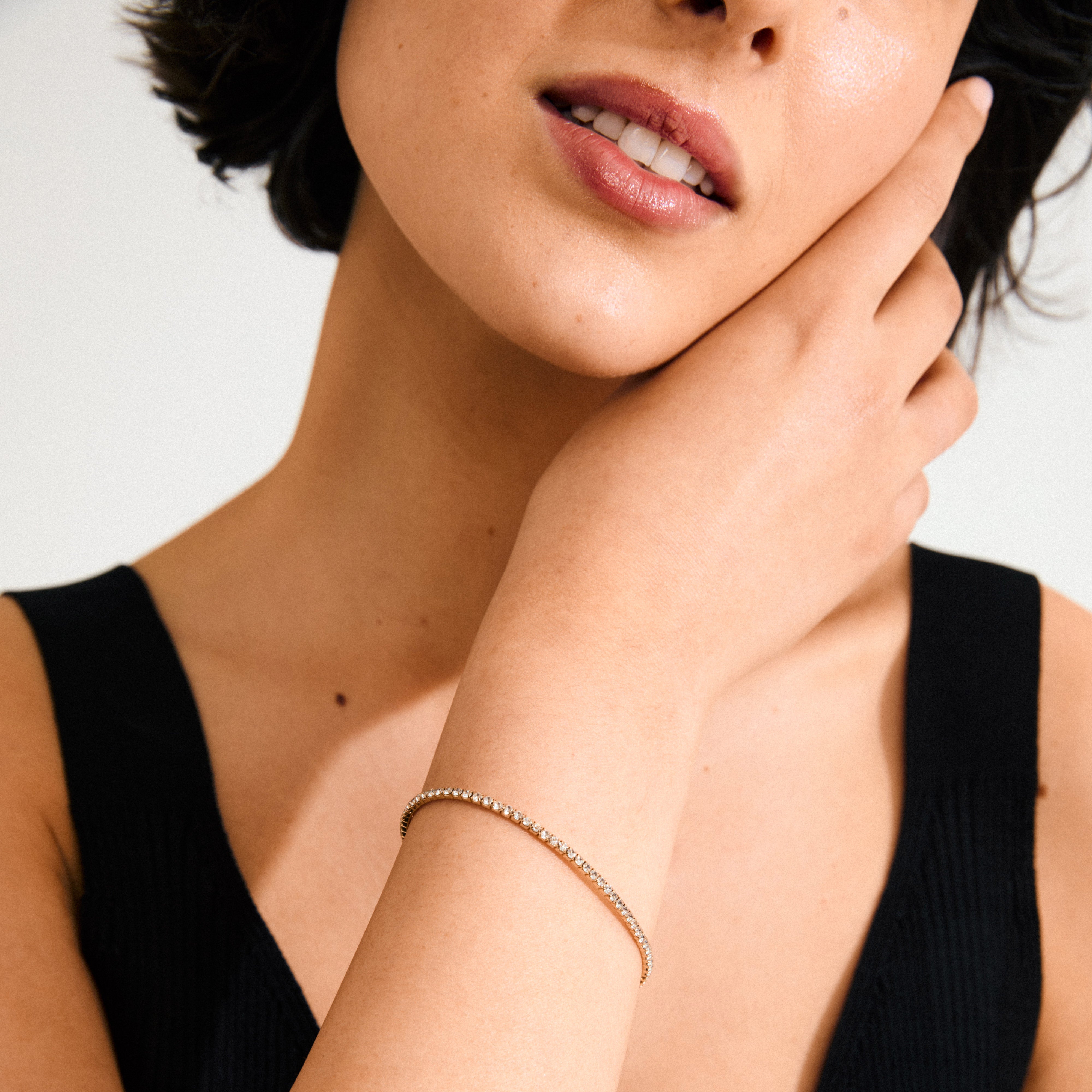 Woman showcasing the ARASH crystal bracelet, gold-plated, adorned with sparkling Preciosa crystals, highlighting its elegant design and comfortable fit on her wrist.
