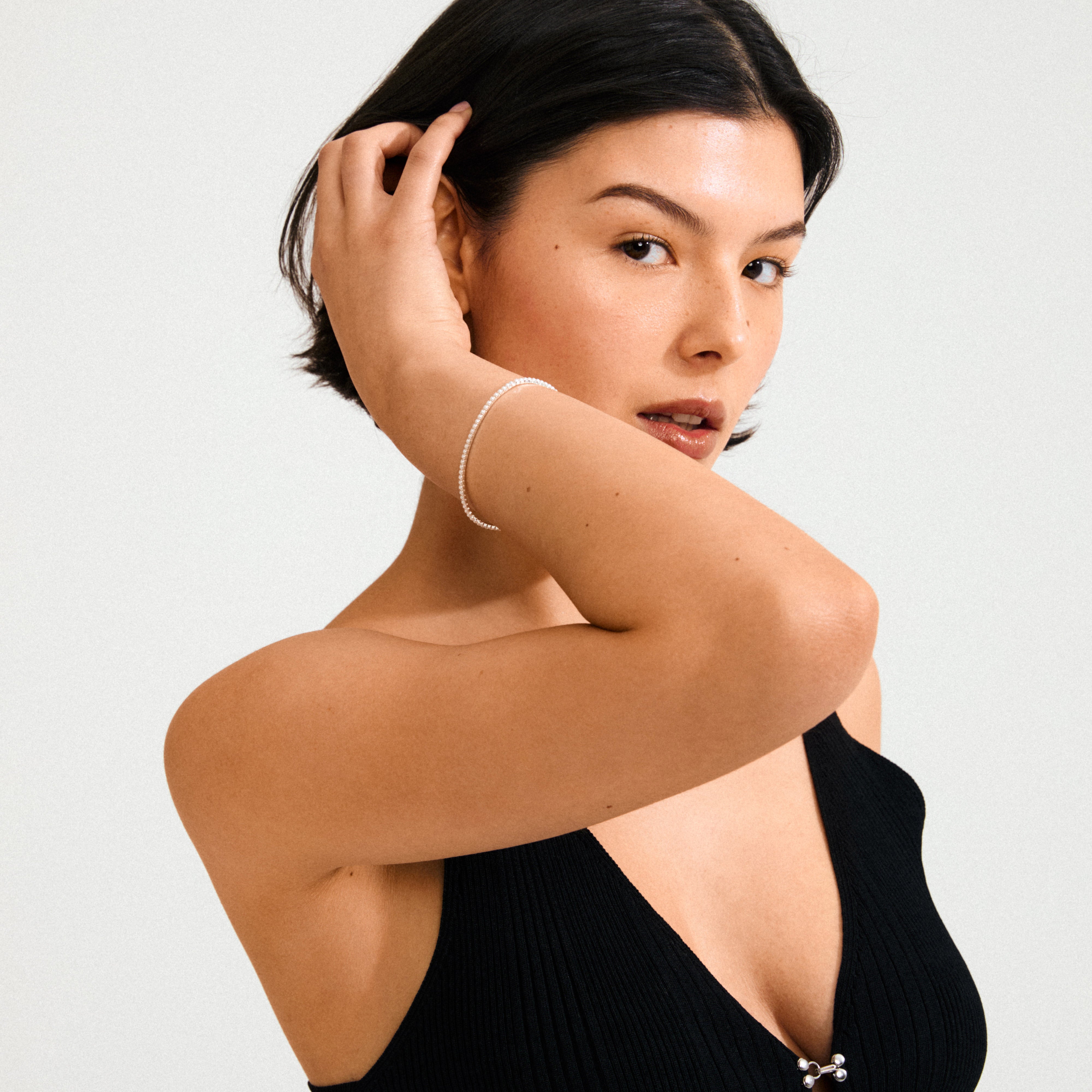 ARASH silver-plated bracelet with mother-of-pearl beads, worn by a model in a black dress, showcasing its elegant, stackable design.