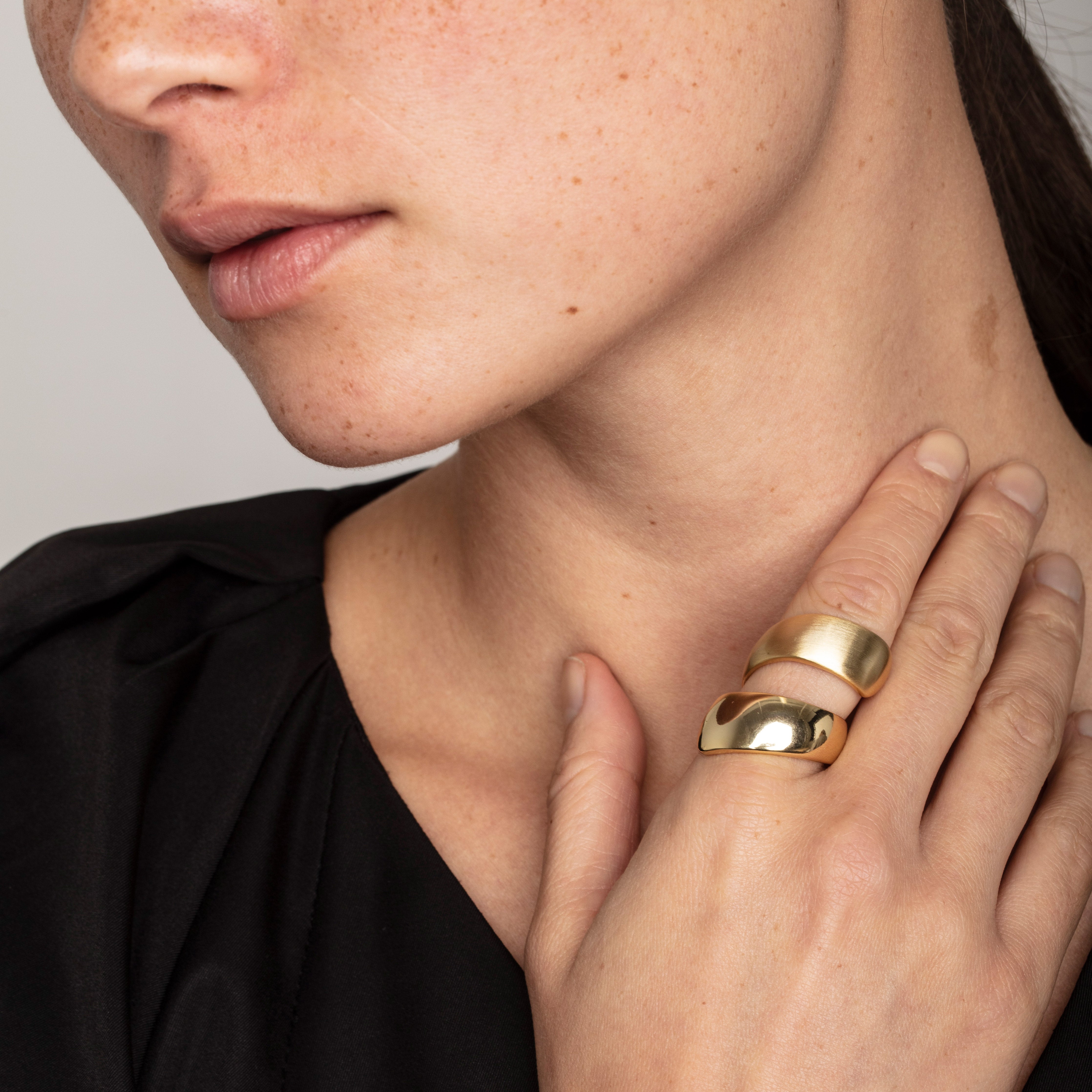 Close-up of a woman's hand adorned with the ALMA gold-plated ring, featuring a double-twined design with contrasting shiny and matte finishes, showcasing Pilgrim's craftsmanship.