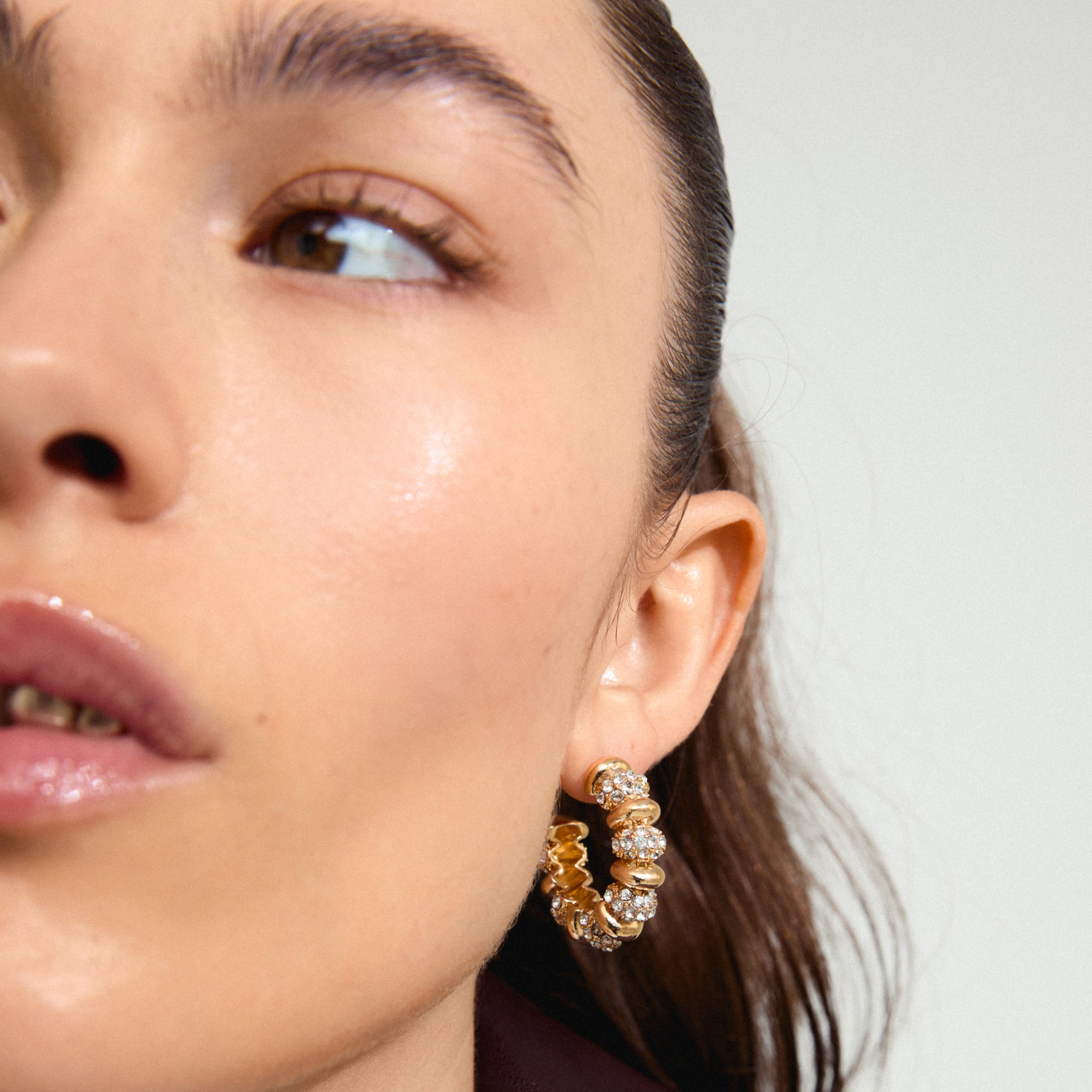DELPHINE gold-plated earrings with Preciosa crystals, showcased by a woman wearing them, highlighting their vintage-inspired hoop design and sparkling details.