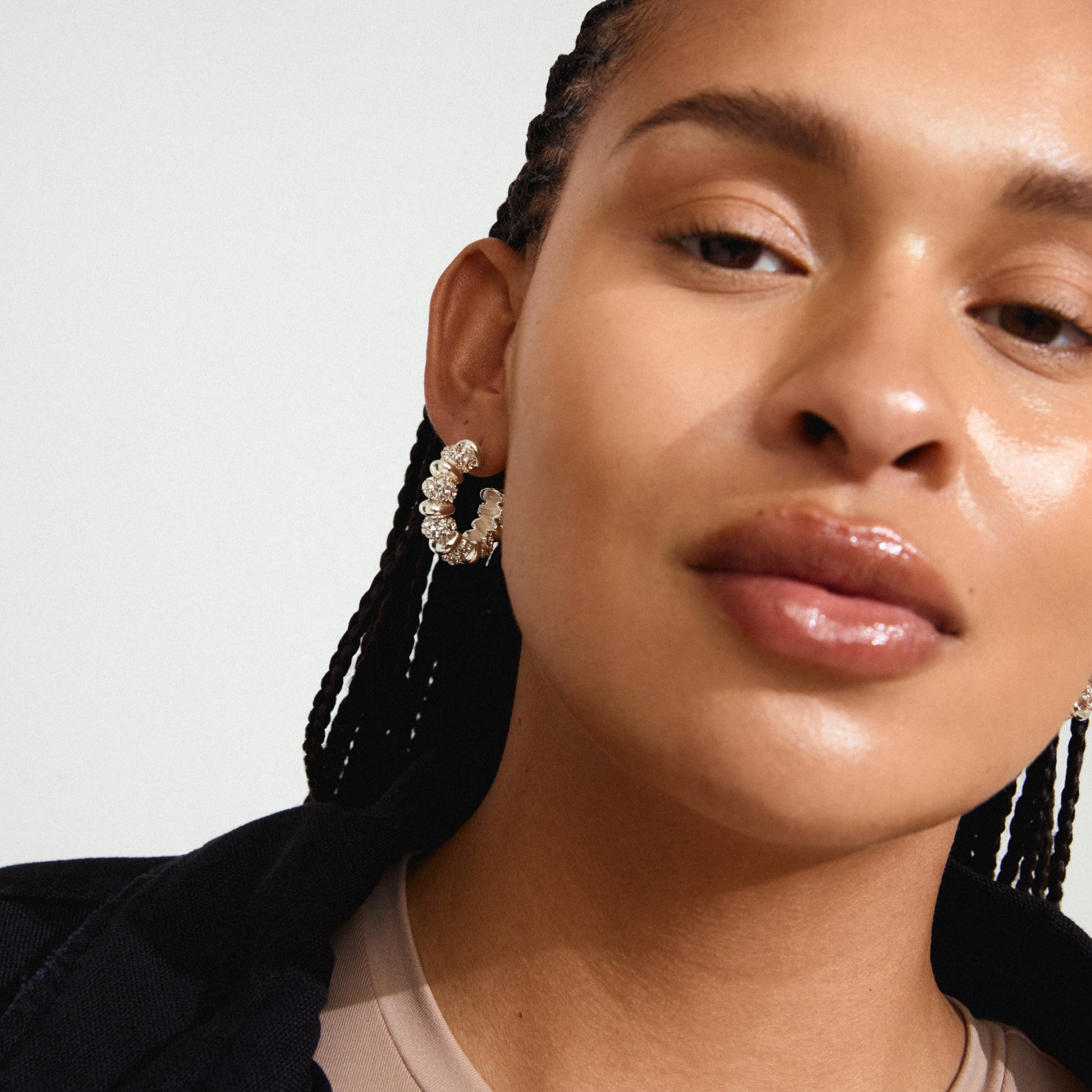 Close-up of a woman showcasing DELPHINE silver-plated earrings with Preciosa crystals, highlighting their vintage-inspired design and sparkle.