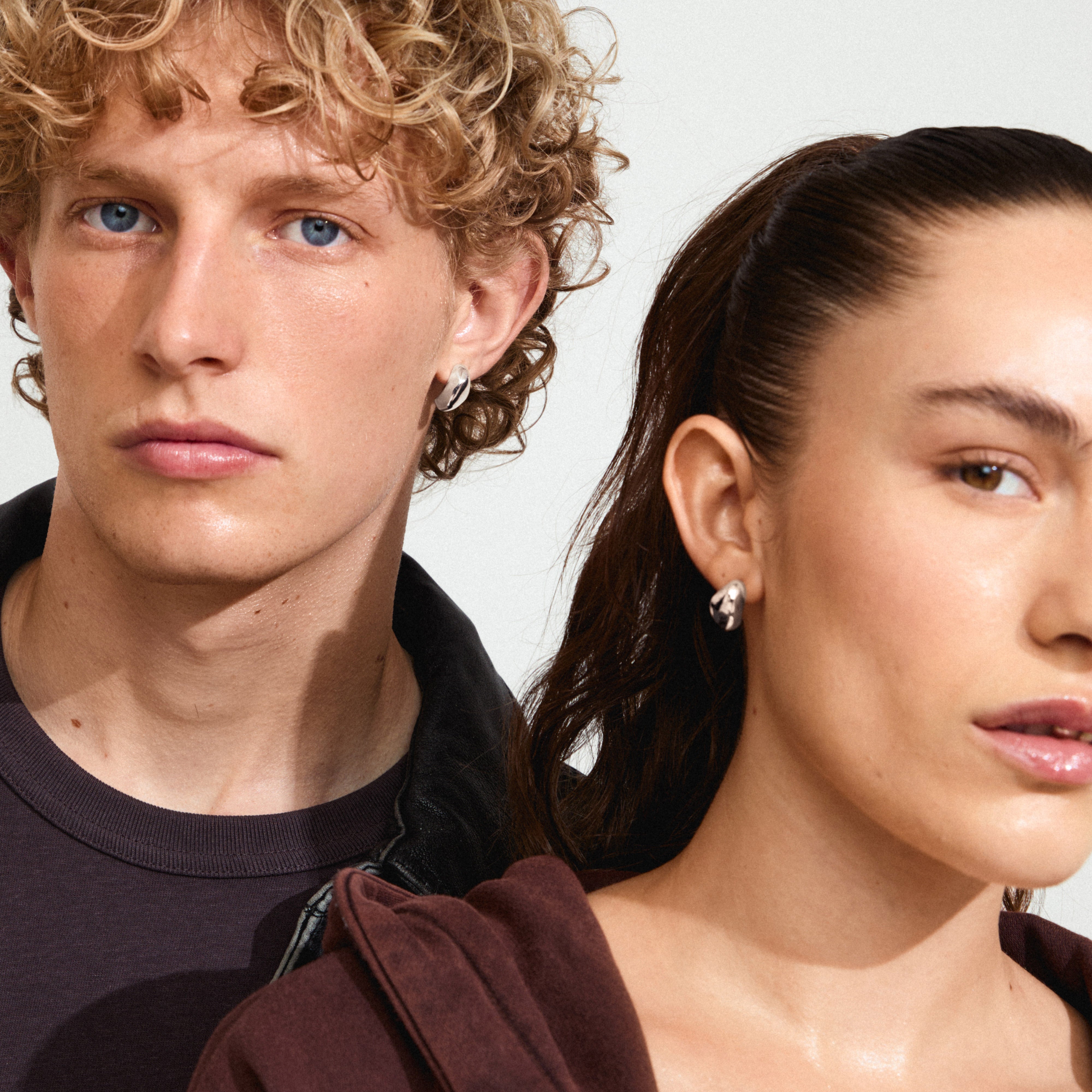 DUNE earrings silver-plated, worn by a woman, showcasing sleek curves and polished finish. Perfect trendy accessory for a chic, stylish look.