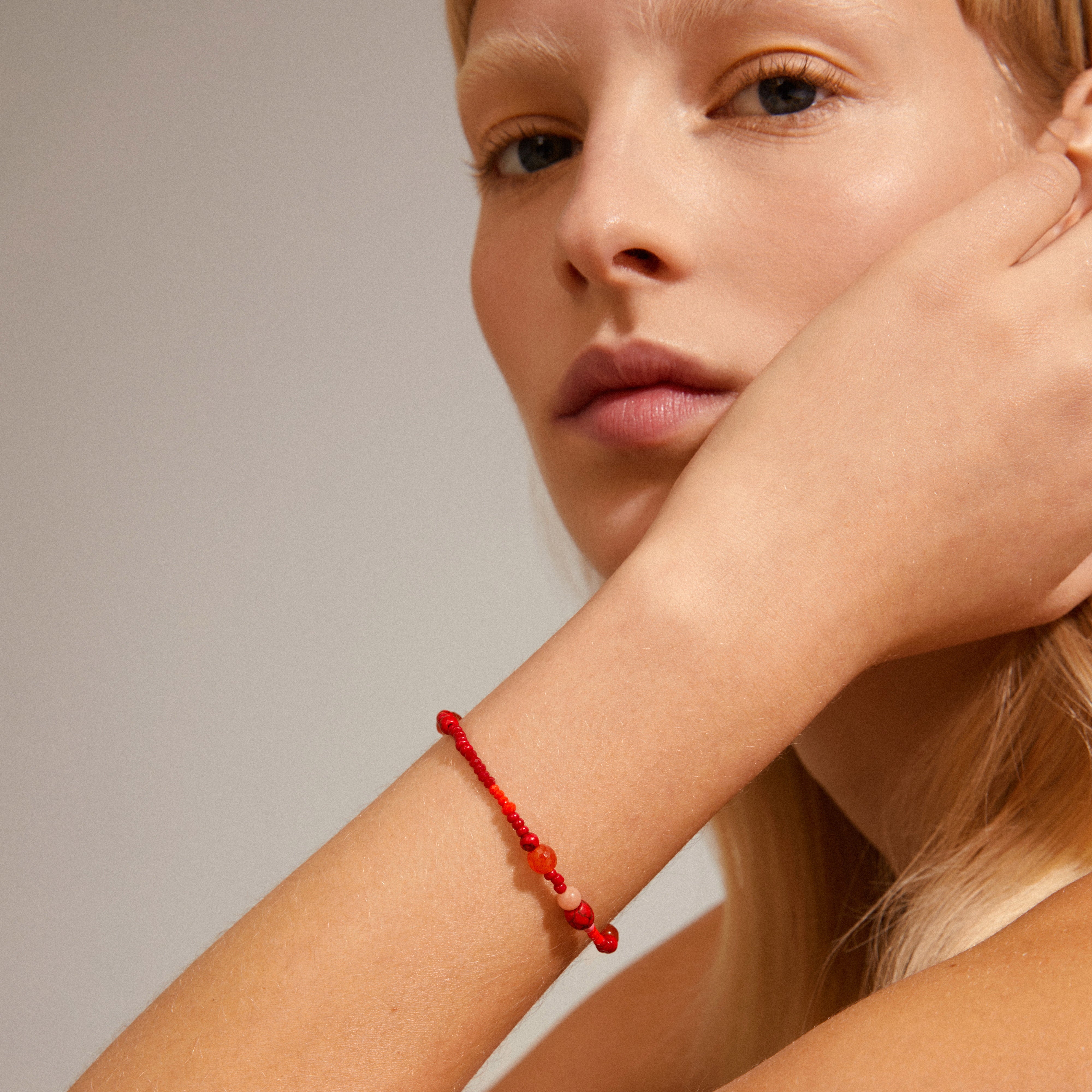 INDIANA bracelet red featuring freshwater pearls and red agate, showcased on a woman's wrist, perfect for a trendy, stacked look with other bracelets.