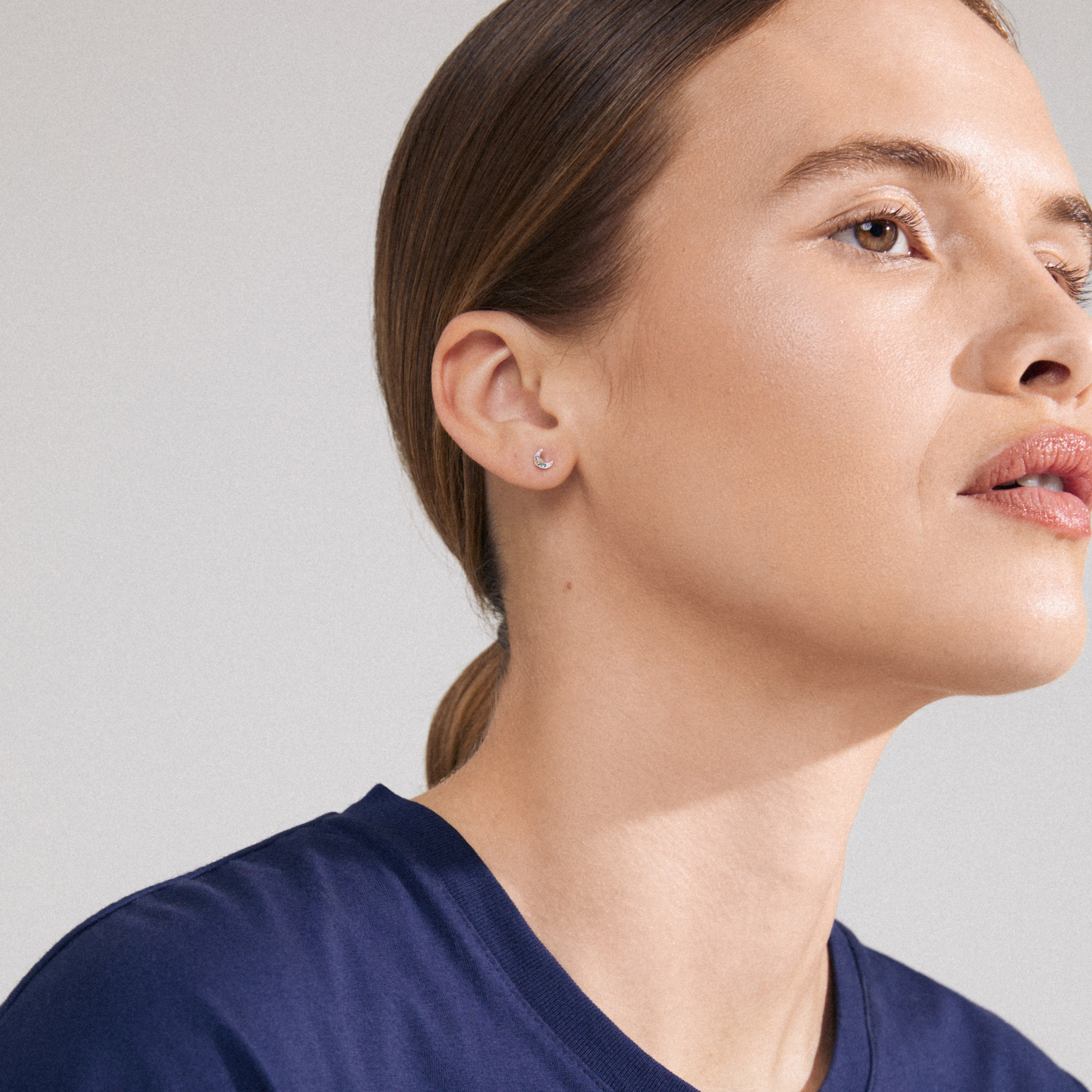 NATASSA single earring silver-plated on woman’s ear, featuring colorful Preciosa crystals for a trendy, asymmetrical look. Ideal for mixing with other earrings.
