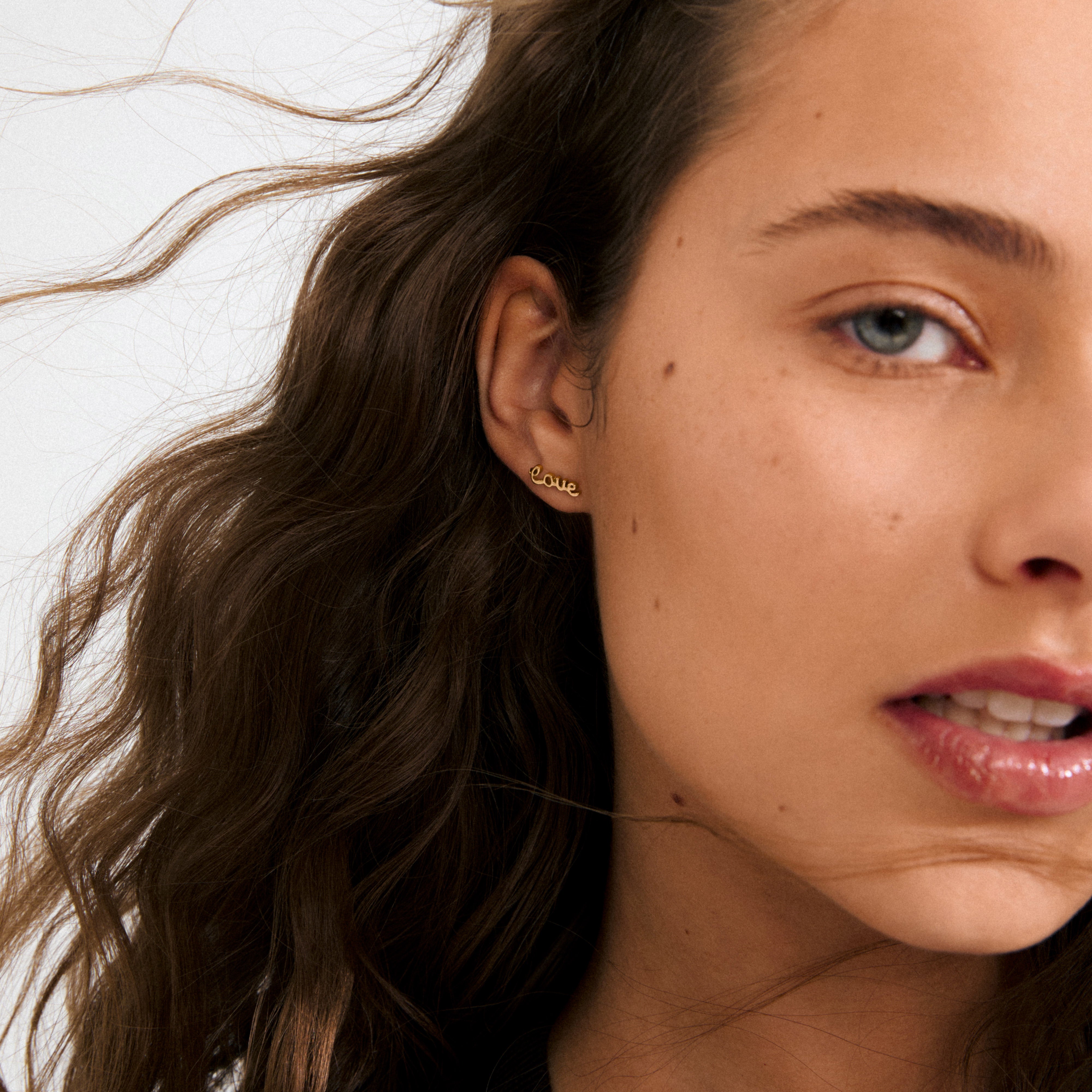 Gold-plated RIO single earring featuring LOVE in elegant letters, crafted from 99% recycled materials for a stylish and meaningful accessory.