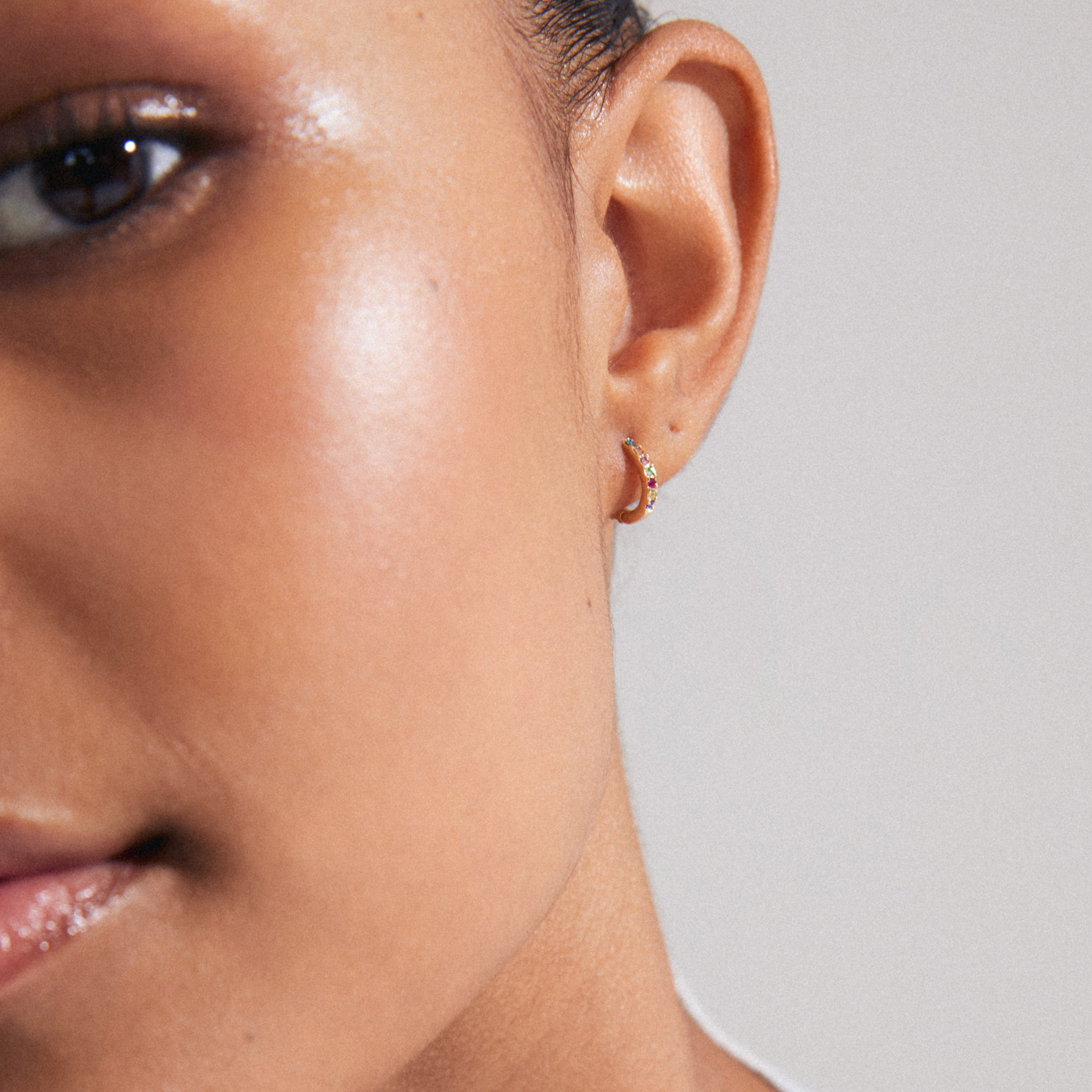 ZOE single earring gold-plated with colorful Preciosa crystals shown close-up on a woman's ear, highlighting its classic design and click clasp.