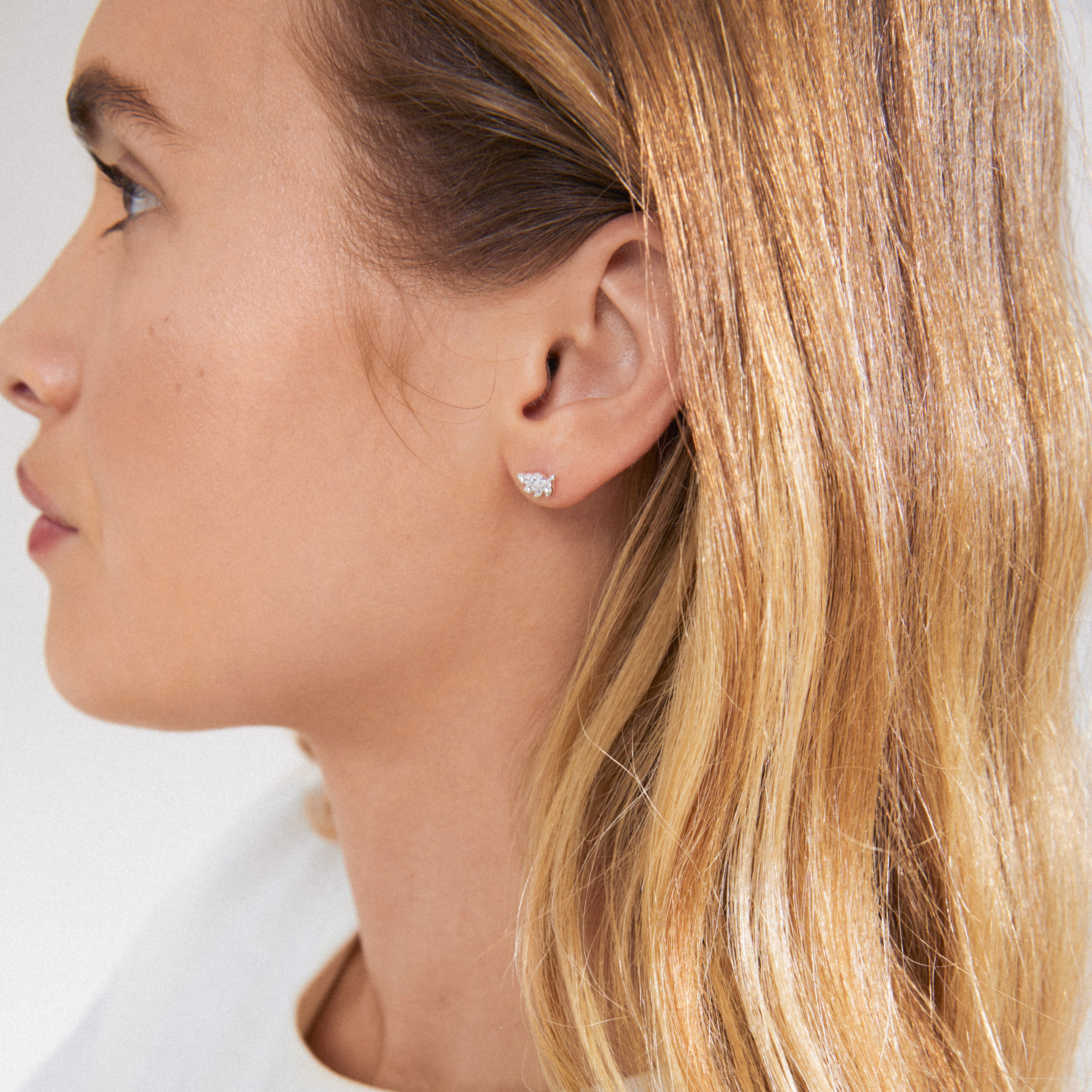 ARES single earring silver-plated features a leaf design with Preciosa crystals, visible in a woman's ear, embodying Pilgrim's Scandinavian elegance and style.