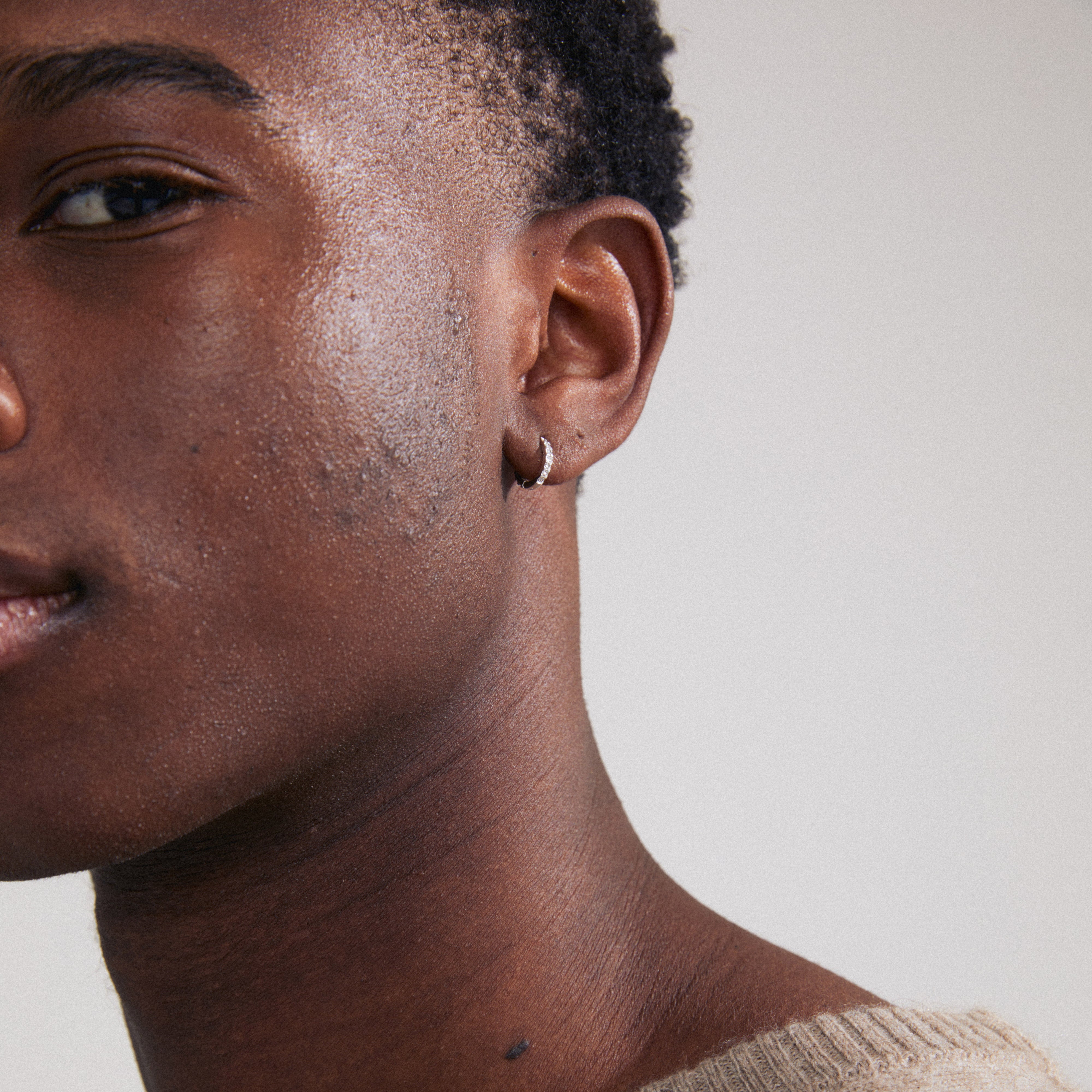 ZOE single silver-plated earring with Preciosa crystals, featuring a click clasp, visible on a close-up of a face.