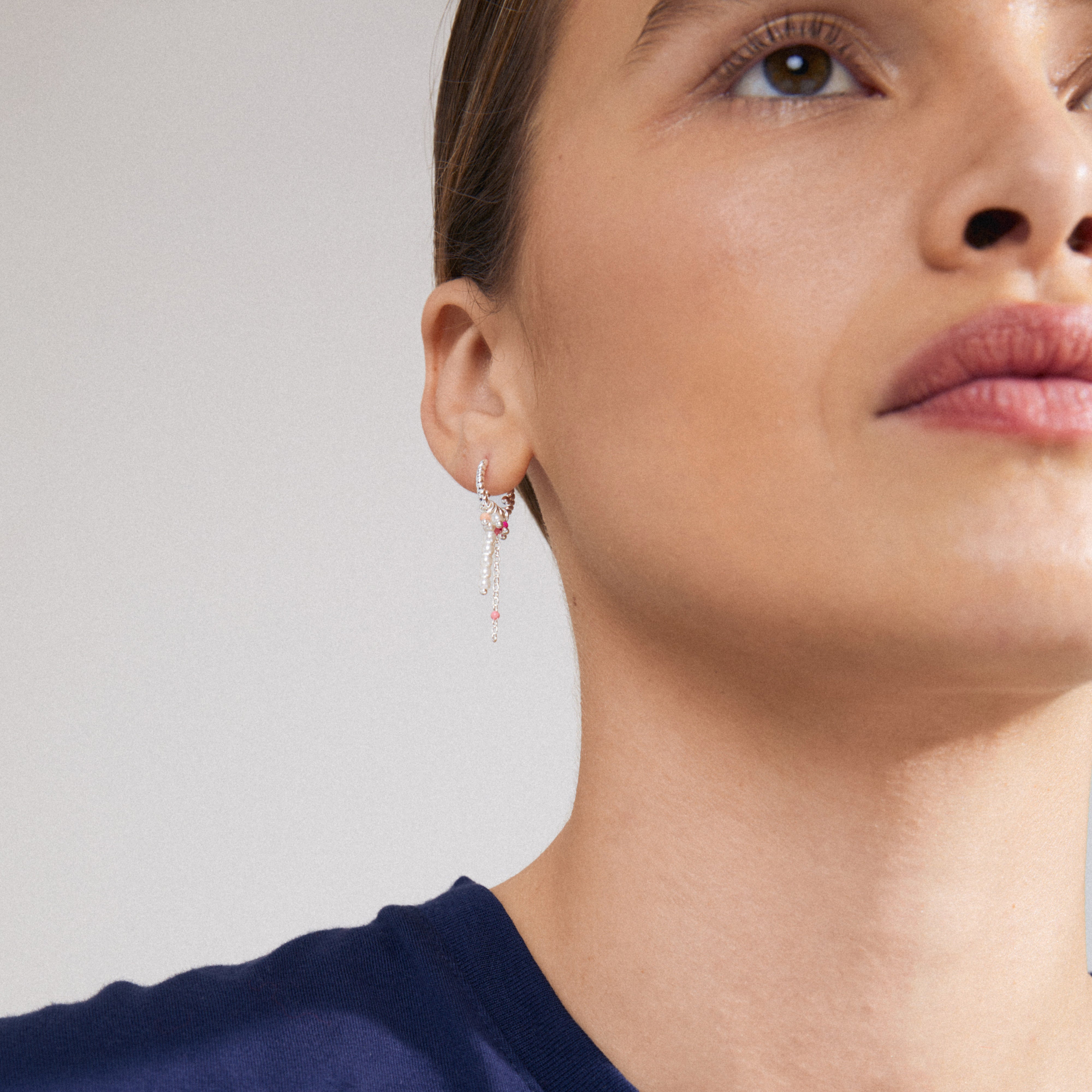 TEKLA single earring, silver-plated with white and pink pearl pendants, showcased on a woman's ear, exuding a playful, summery lux-boho vibe.