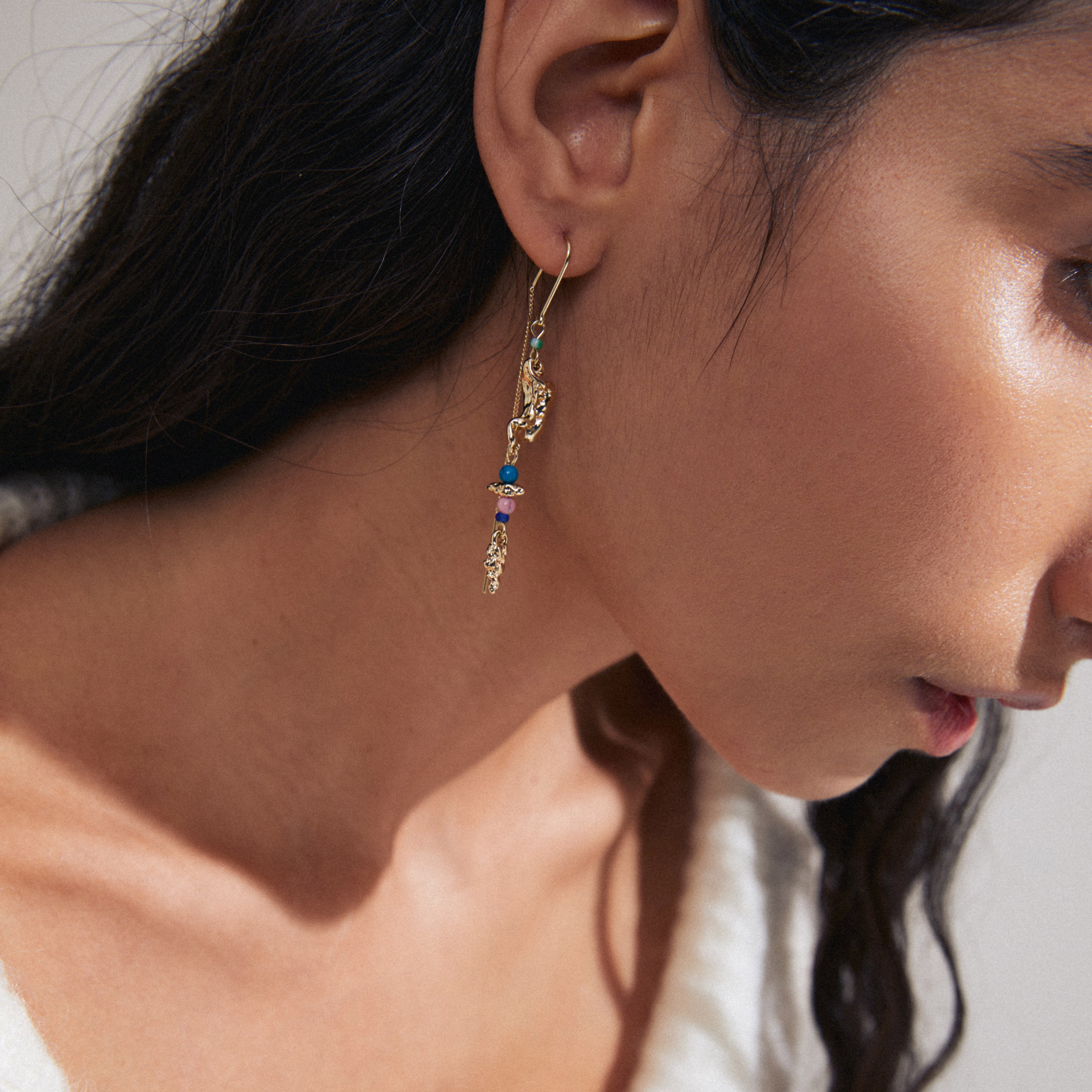 SELENE single earring gold-plated featuring a handcrafted design with colorful beads, worn by a woman, showcasing a playful, boho-chic style.