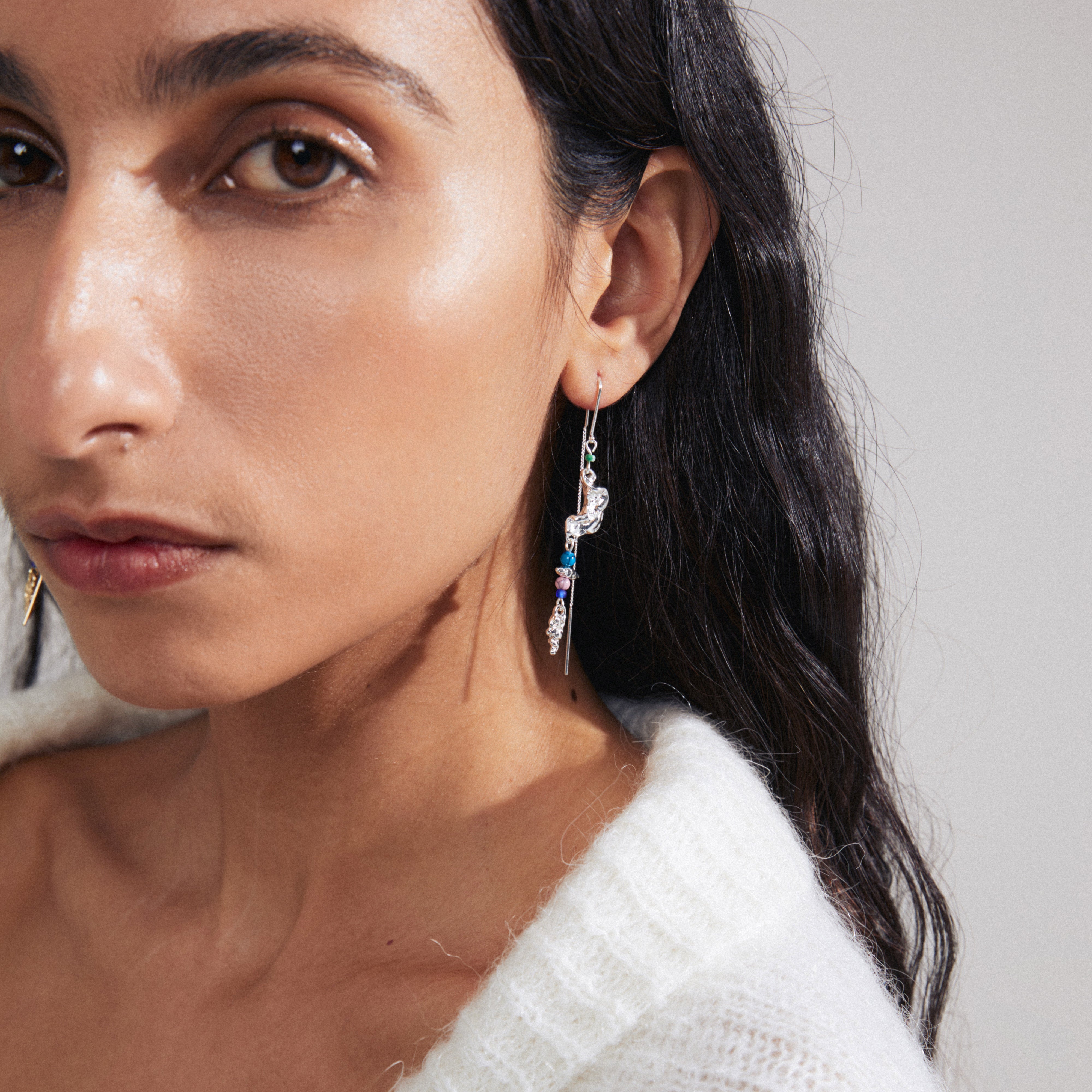 Woman wearing SELENE single earring, a silver-plated chain with colorful beads, showcasing an organic, handcrafted design.