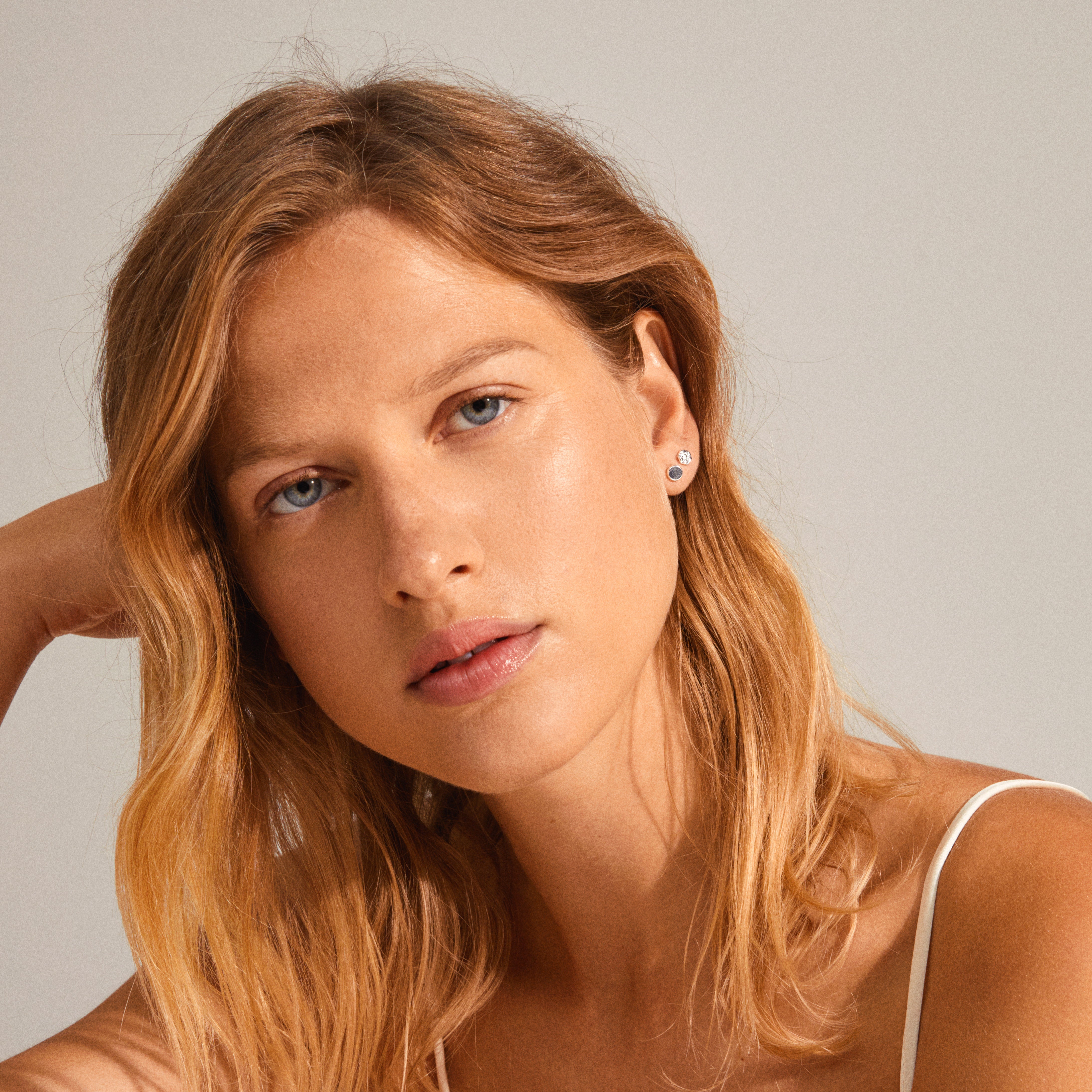 LEAF 2-in-1 set earrings silver-plated, highlighting smooth and rustic finishes, worn by a woman with blonde hair in a close-up portrait.