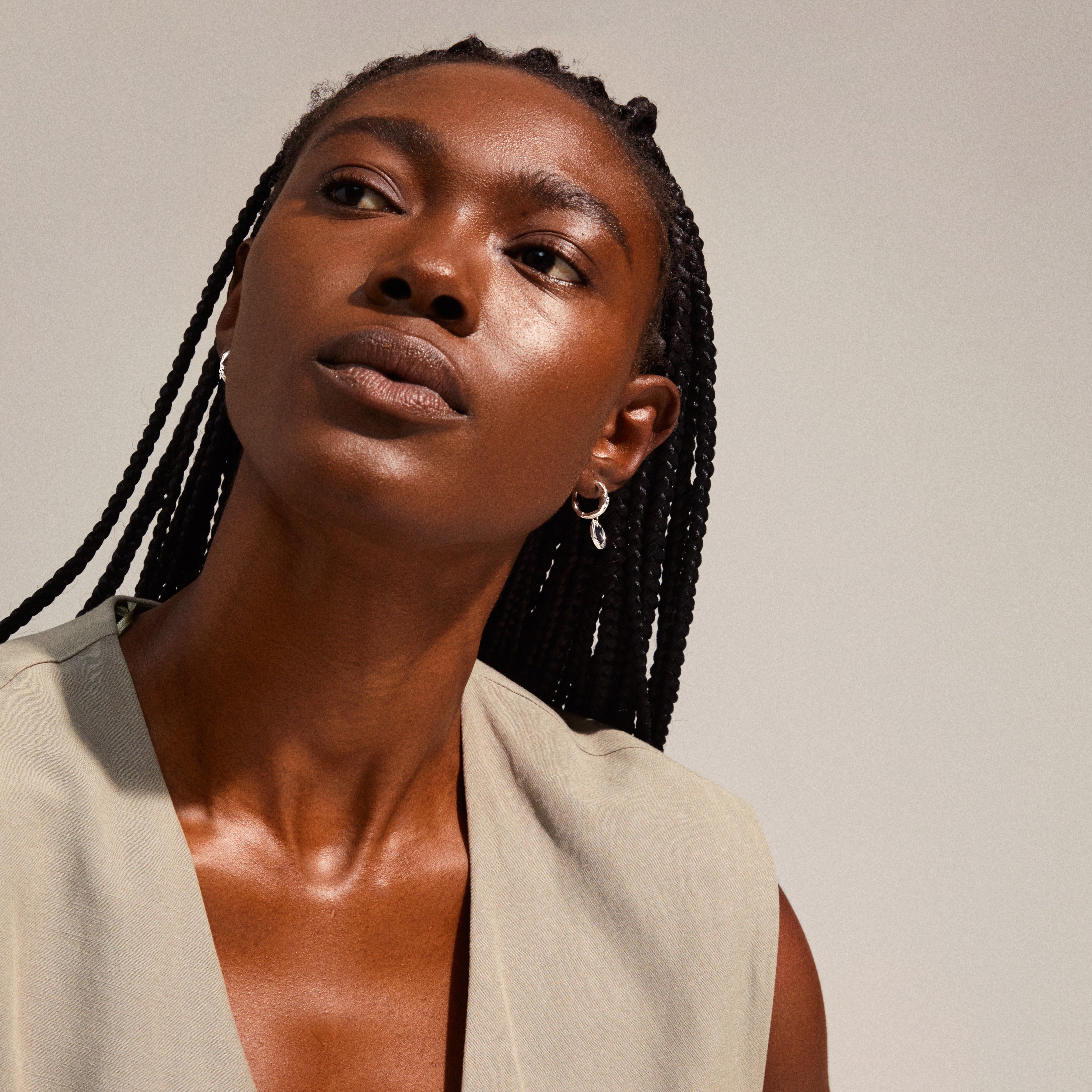 LEAF coin hoops silver-plated earrings with braided-haired woman showcasing the bohemian-style recycled jewelry, emphasizing unique organic shapes and eco-friendly design.