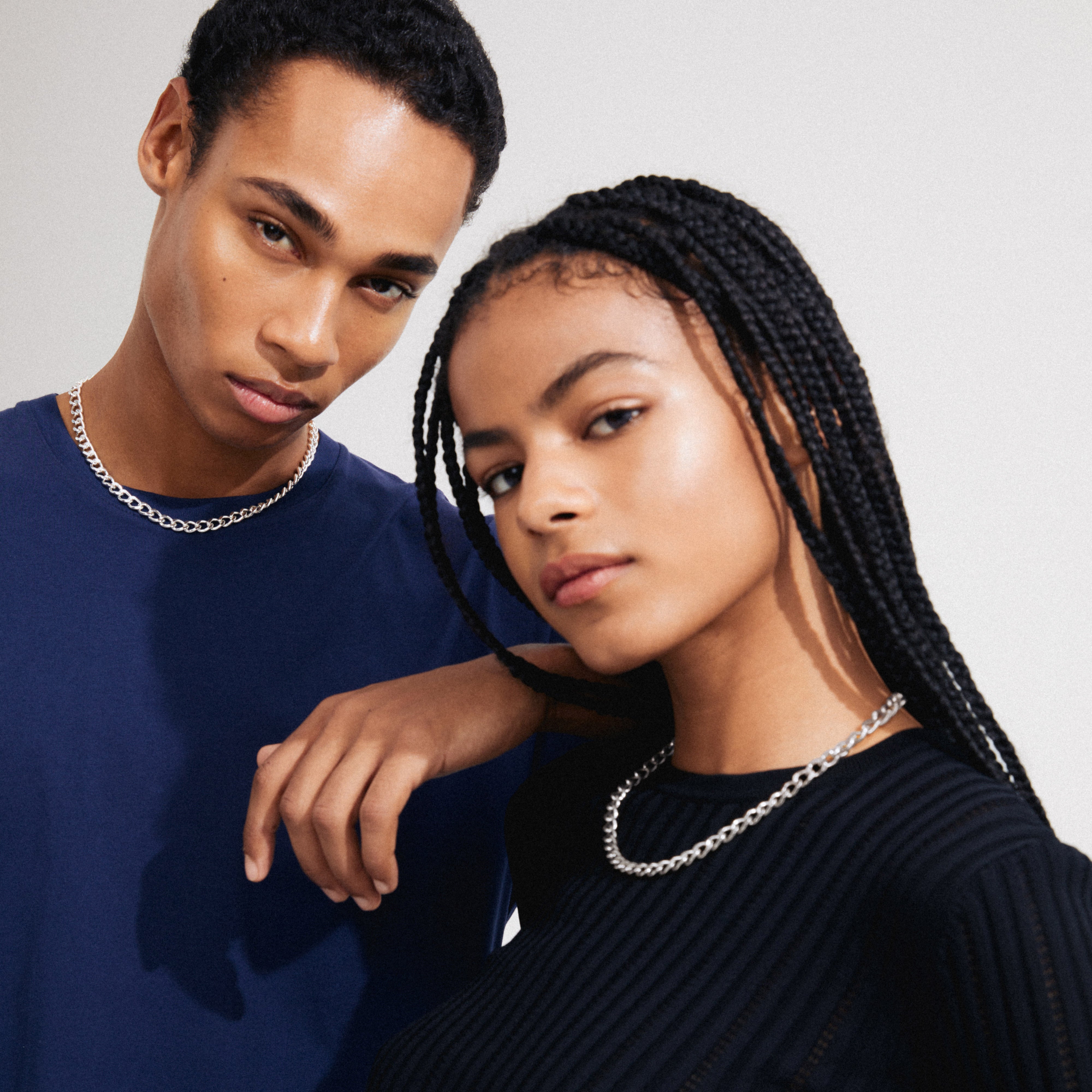 Man and woman showcasing the CHARM curb necklace silver-plated, a stylish, adjustable curb chain perfect for adding charms and creating an edgy, urban look.