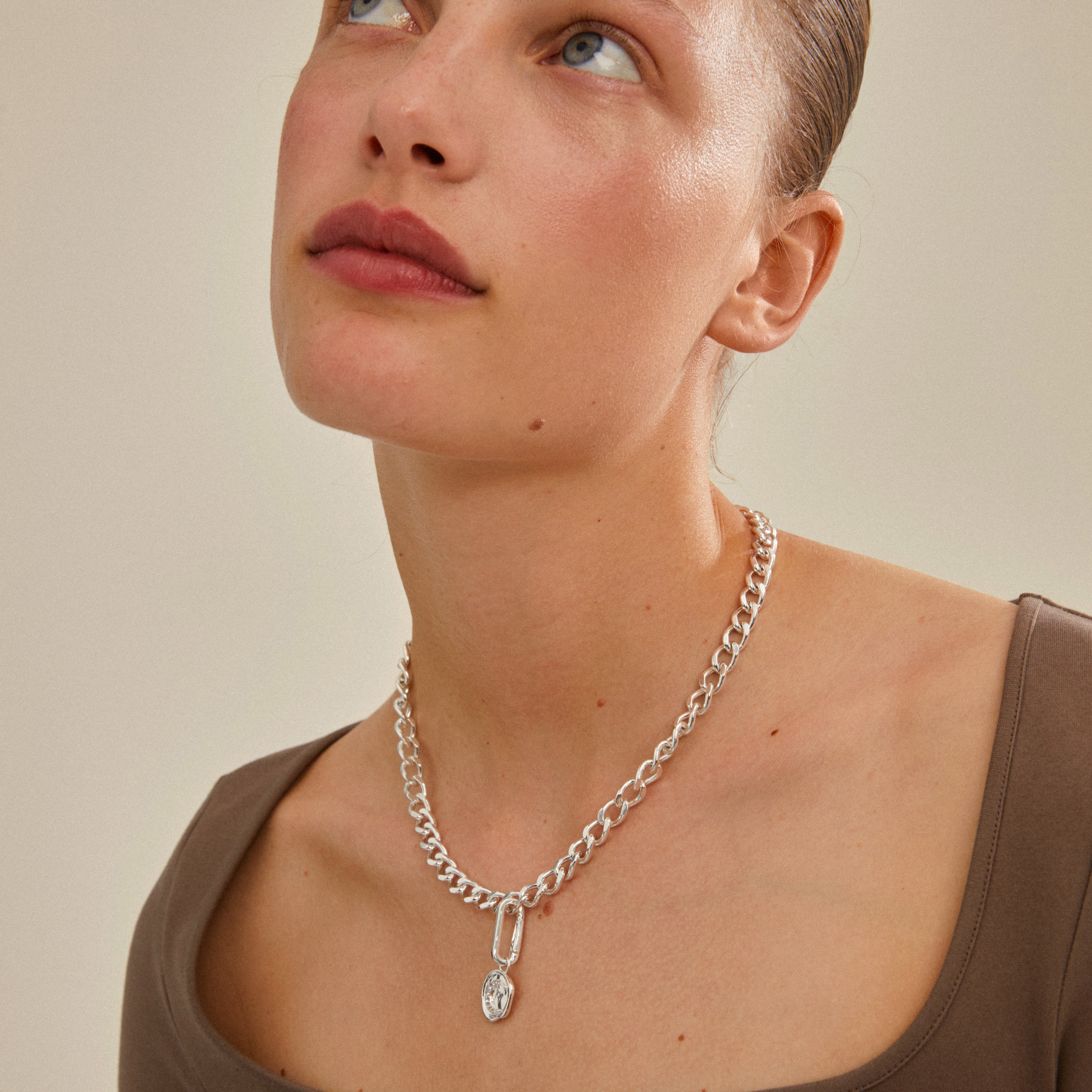 Silver-plated CHARM moon pendant on a woman's neck, showcasing Pilgrim's blend of timeless and trendy design, ideal for personalized jewelry styling.