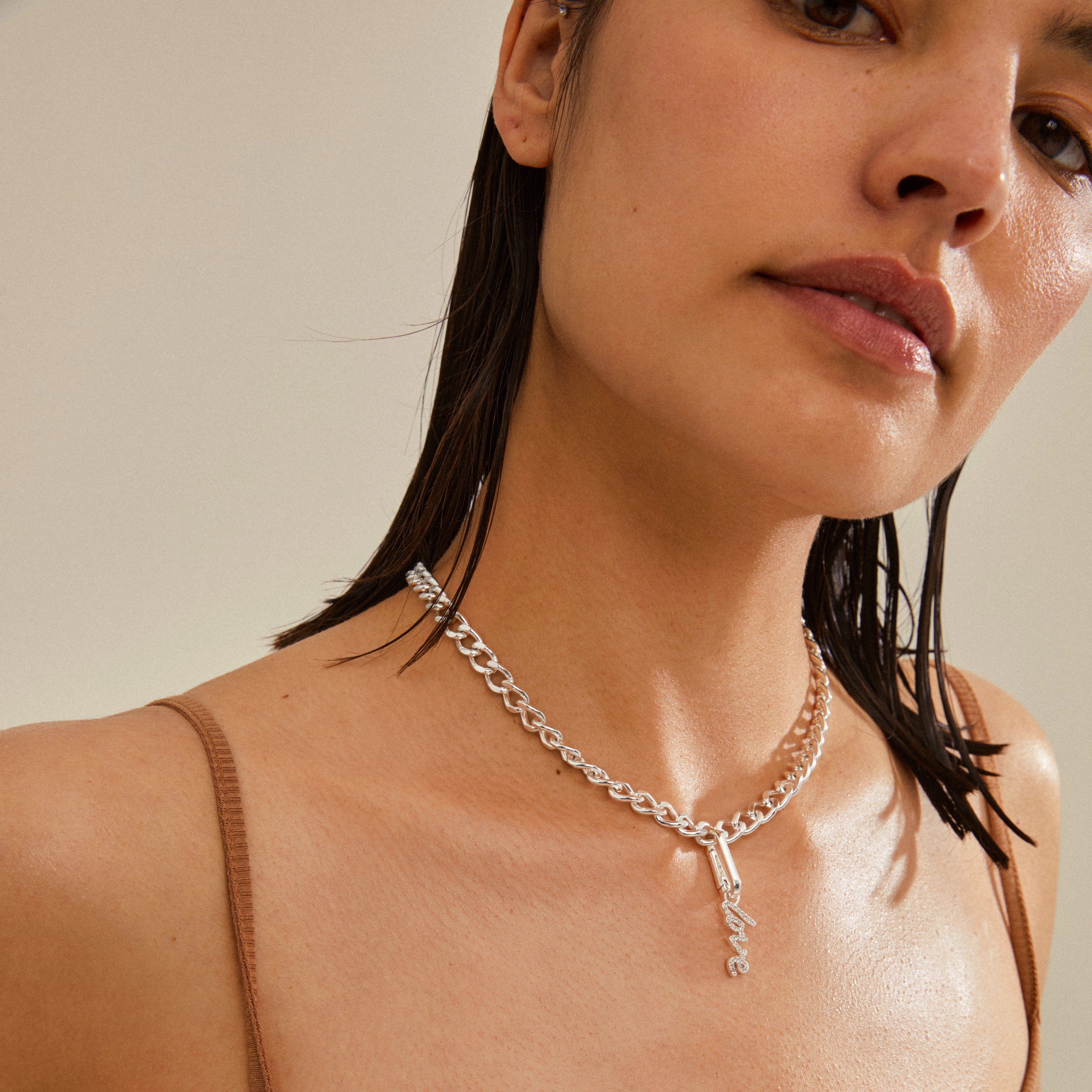 Silver-plated CHARM love pendant on a woman, showcasing its elegant design and versatility for personalized styling with other accessories.