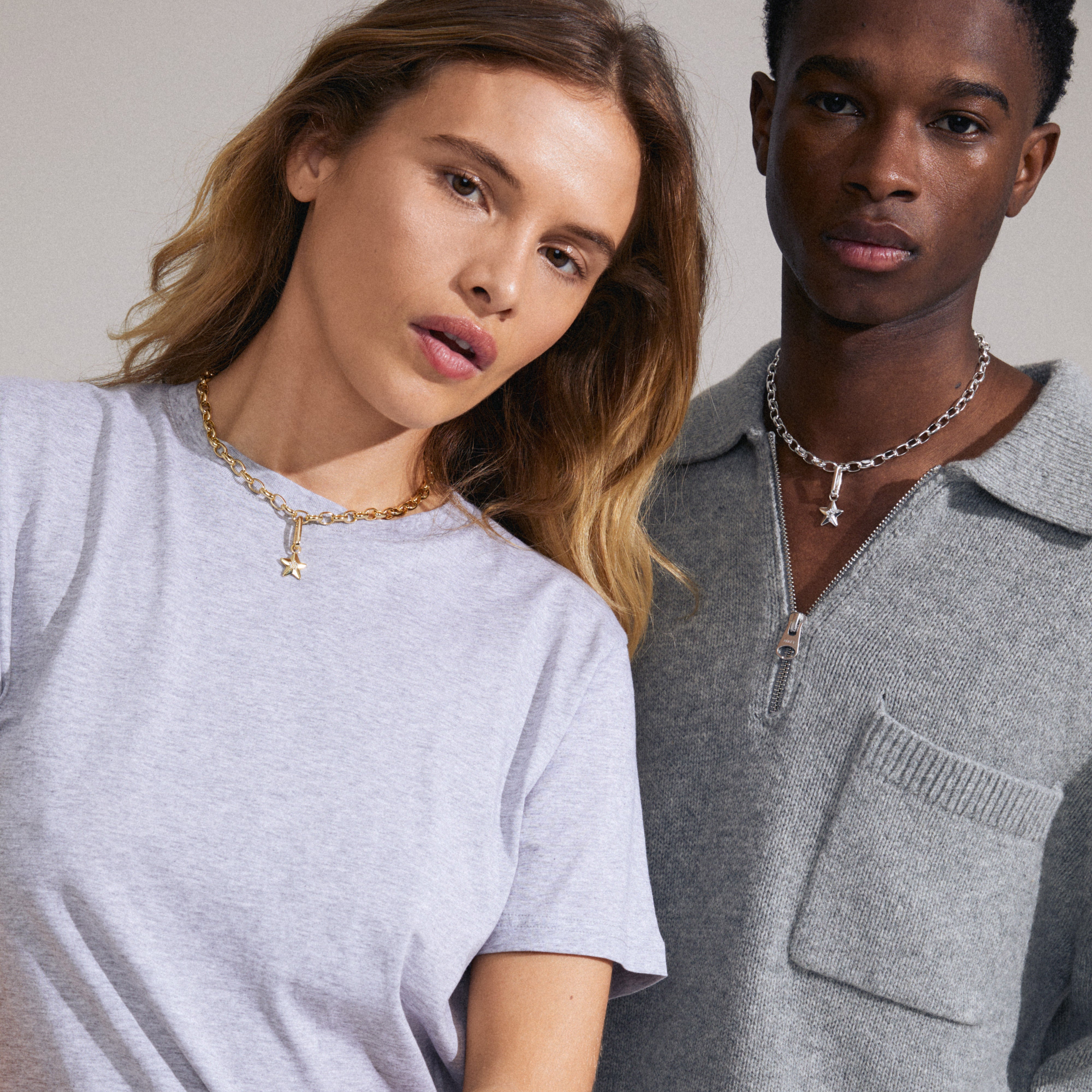 A woman wearing the Pilgrim CHARM star pendant, gold-plated, featuring Preciosa crystals, ideal for personalized, trendy styling with a chunky cable chain.