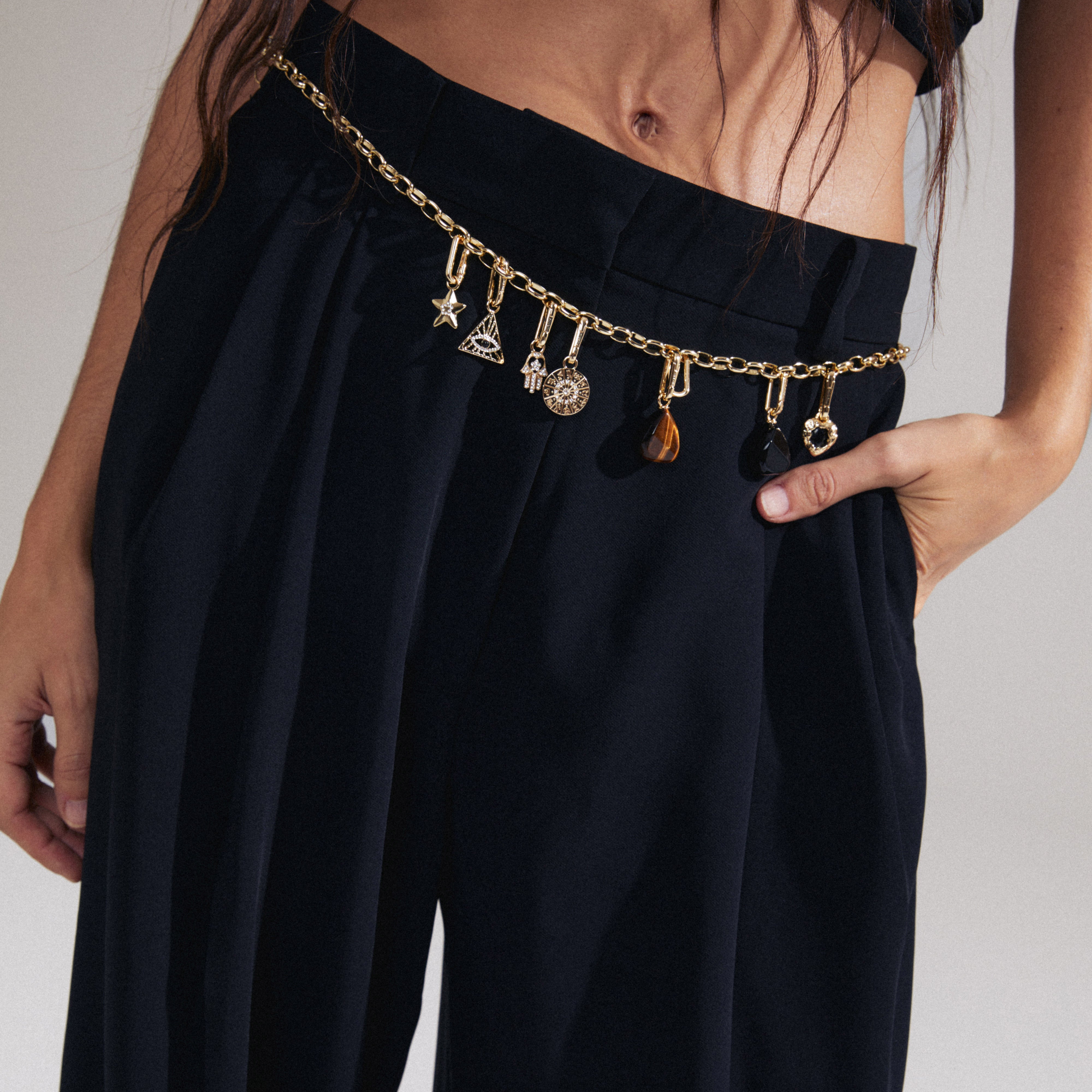 Woman showcasing Pilgrim's CHARM black agate pendant, gold-plated, with a chunky cable chain, highlighting a unique, personalized style with Scandinavian flair.