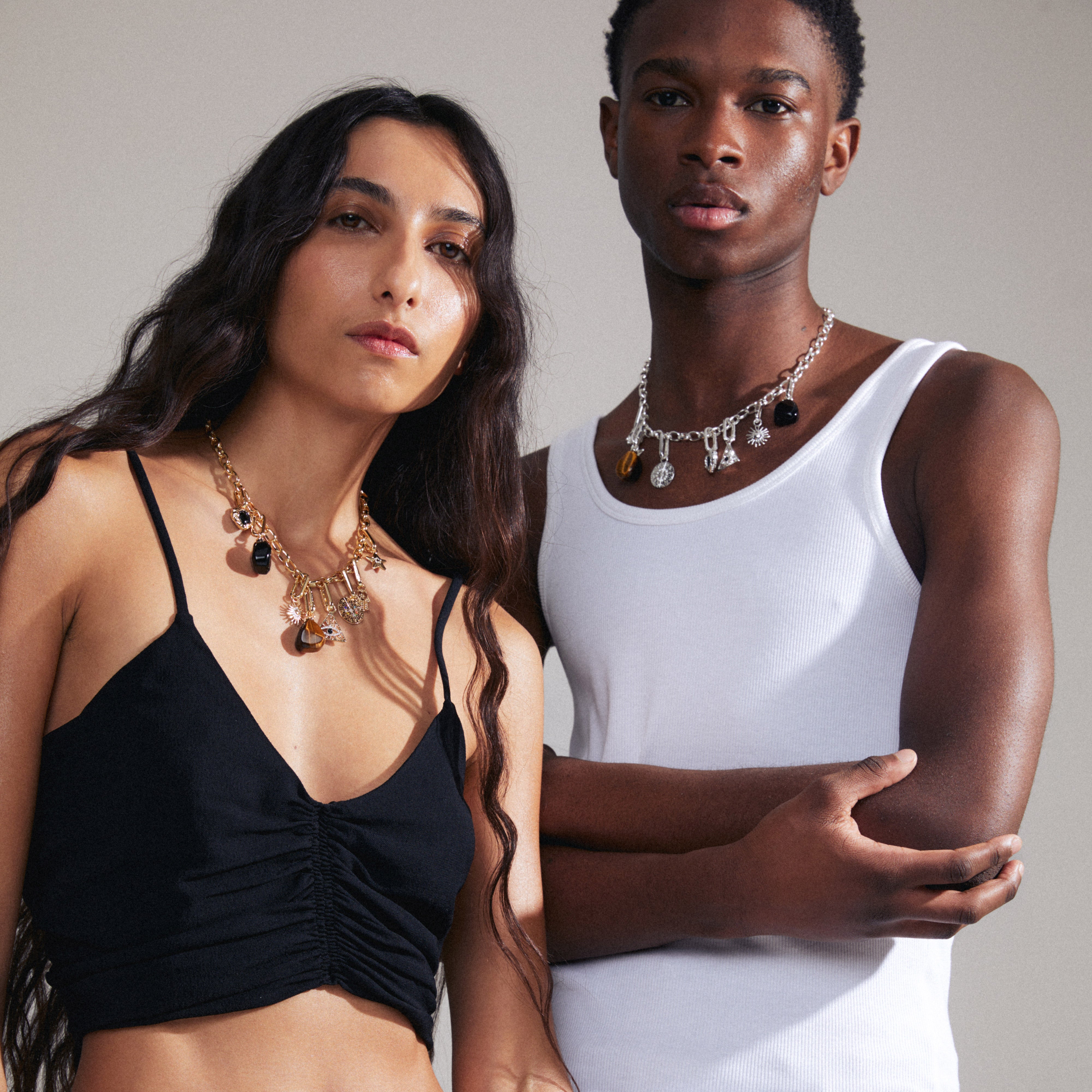 A man and woman showcase the CHARM black agate pendant, gold-plated, highlighting its versatility and stylish appeal as a personal fashion statement.